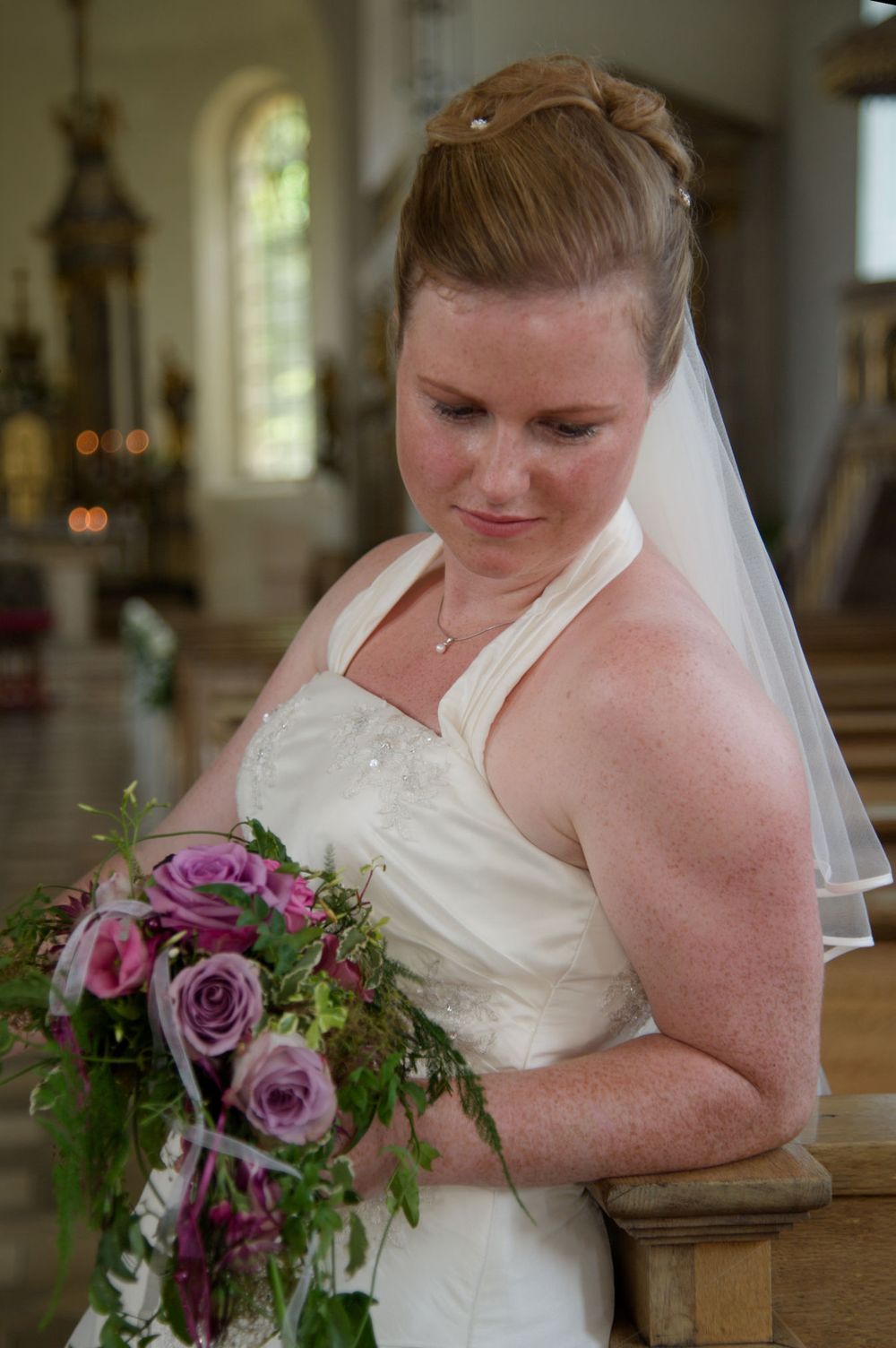 Wunderschönes Brautporträt mit Blumenstrauß in einer Kirche. Professionelle Hochzeitsfotografin Cornelia von Lichtkapsel in Eggolsheim.