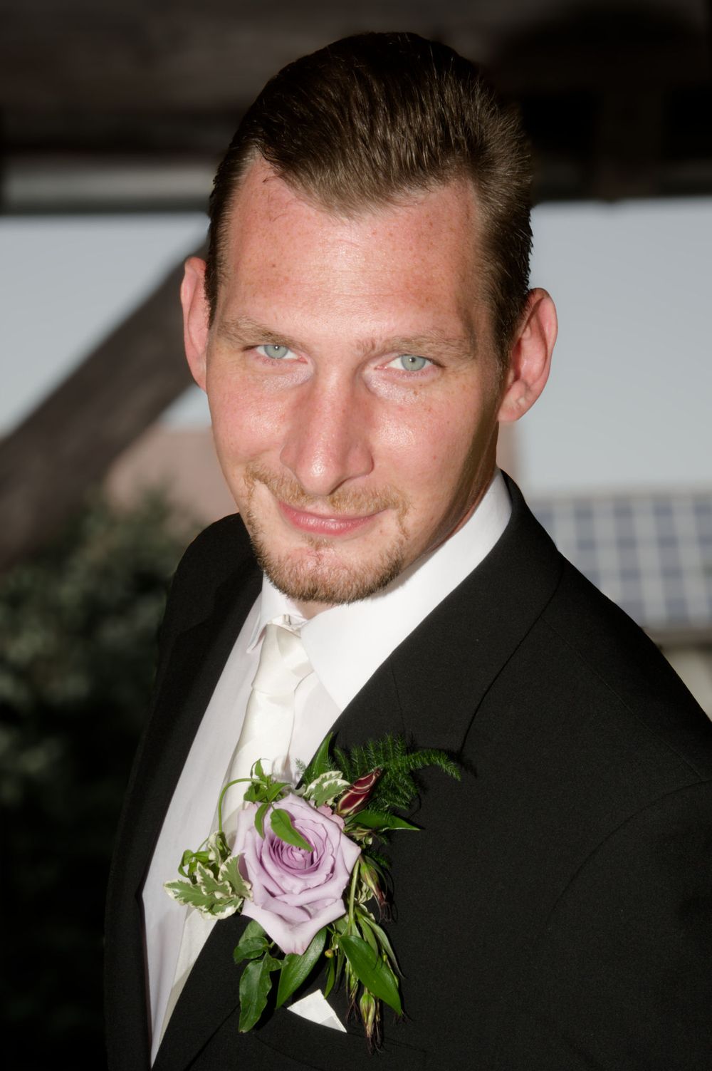 Stilvolles Porträt des Bräutigams mit Blumen-Anstecker am Revers. Professionelle Hochzeitsfotografie am Standort Eggolsheim.