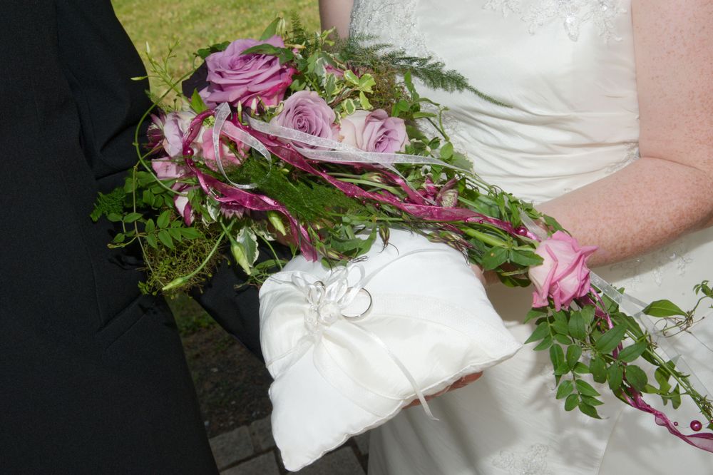 Nahaufnahme eines floralen Brautstraußes mit elegantem Ringkissen. Liebevolle Hochzeitsdetails fotografiert in Eggolsheim.