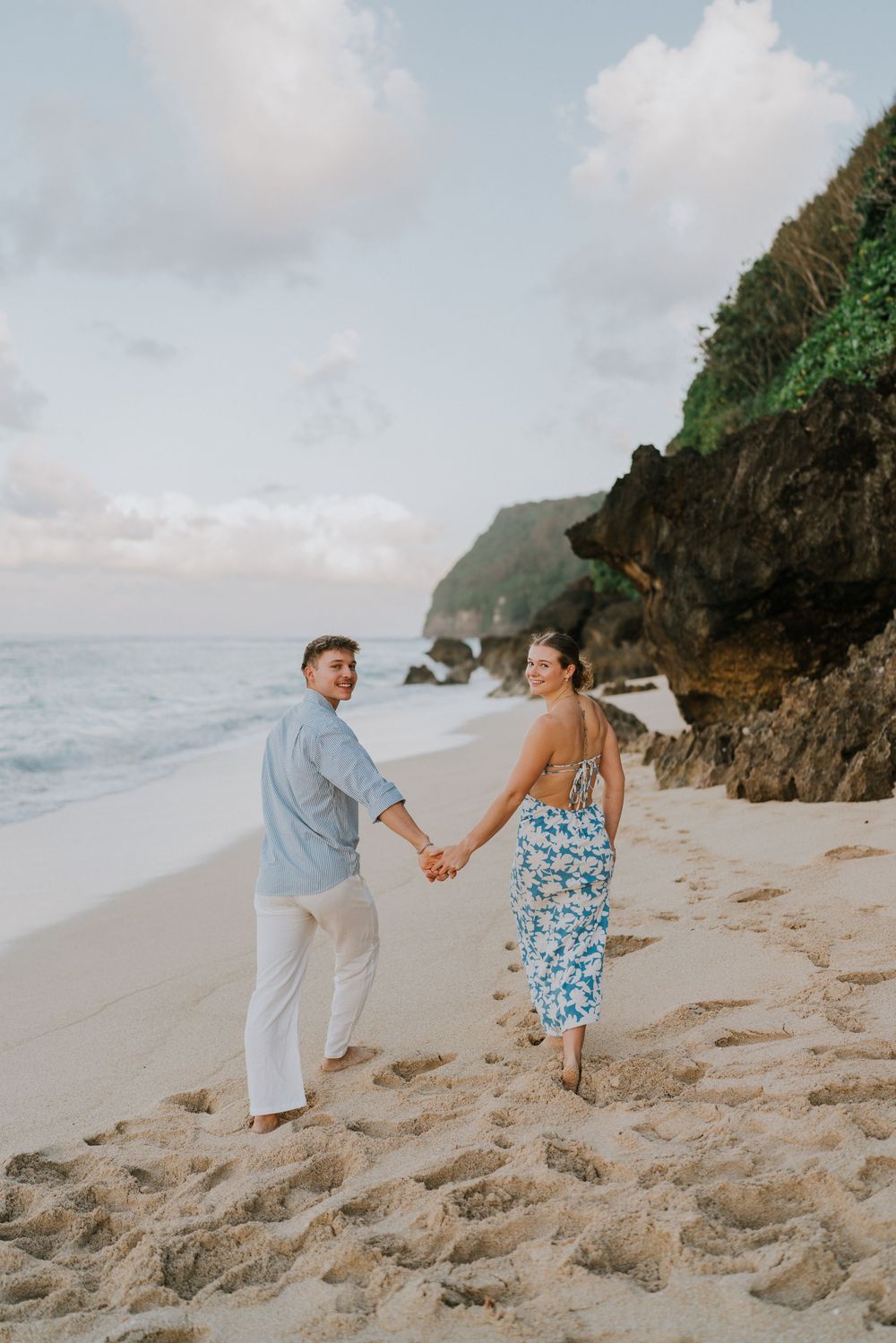 Romantic surprise proposal at Melasti Beach Bali during golden hour.