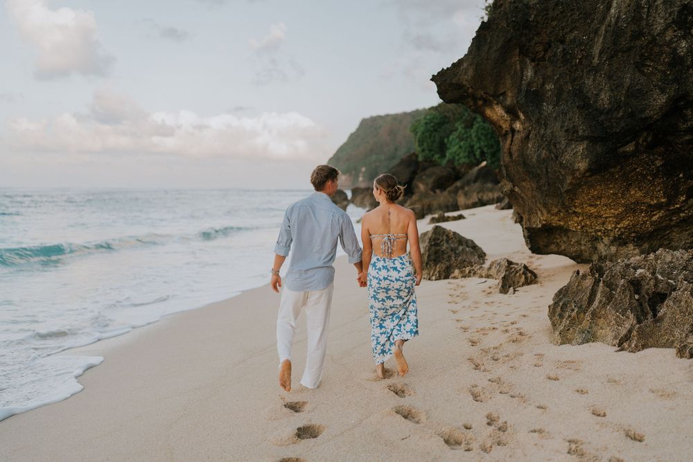Romantic surprise proposal at Melasti Beach Bali during golden hour.