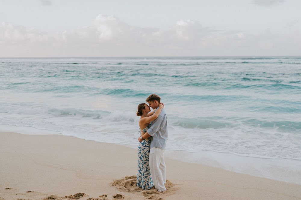 Couple celebrating engagement at Melasti Beach with ocean backdrop.