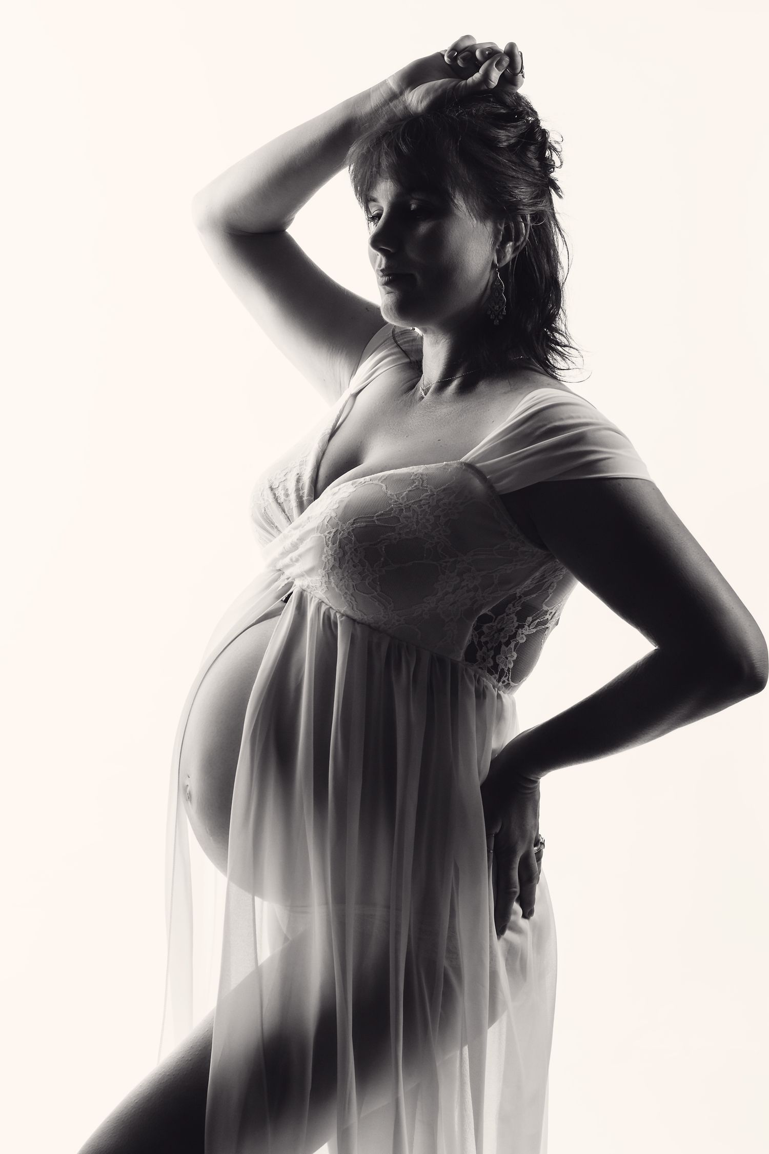 Elegant backlit maternity portrait captured in a North Auckland photography studio in Warkworth