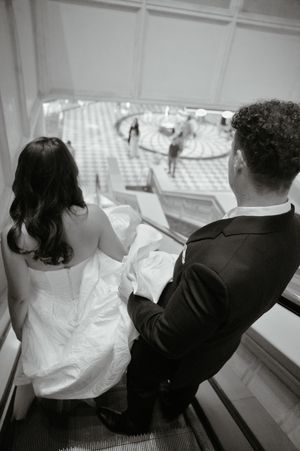 Black and white photo of bride and groom descending an escalator at a Las Vegas wedding venue.