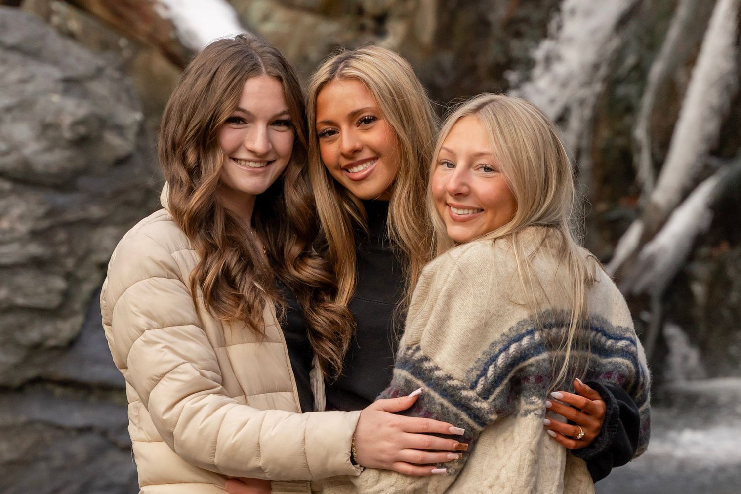 Senior rep team group photo, wearing comfy sweaters in front of a Maryland waterfall