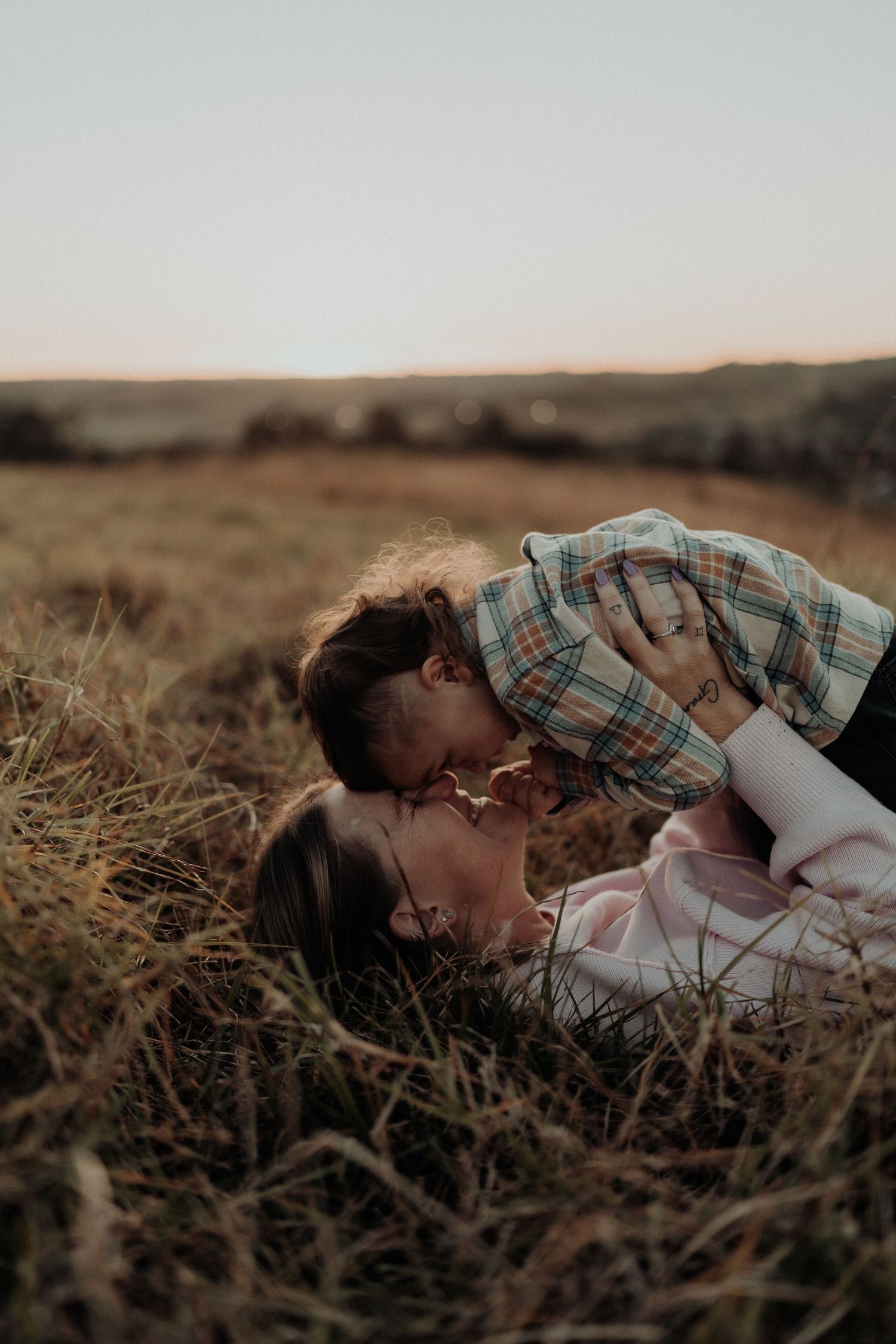 mother and sun cuddle in a field at sunset in Picton NSW
