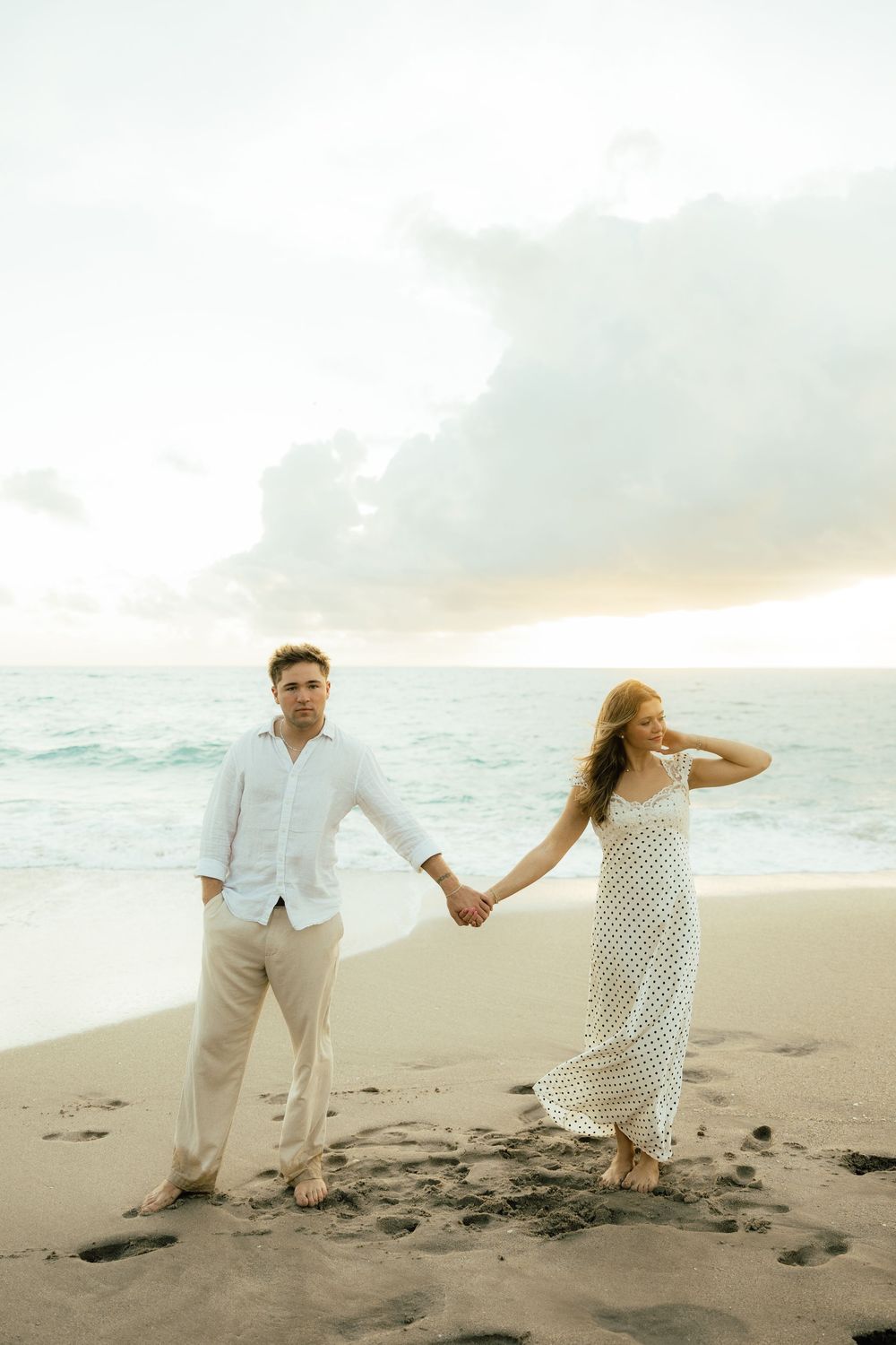 Playful sunrise beach engagement photos with golden light and bright blue waters. Jacksonville Engagement Photographer - Lindsay McDow Photo