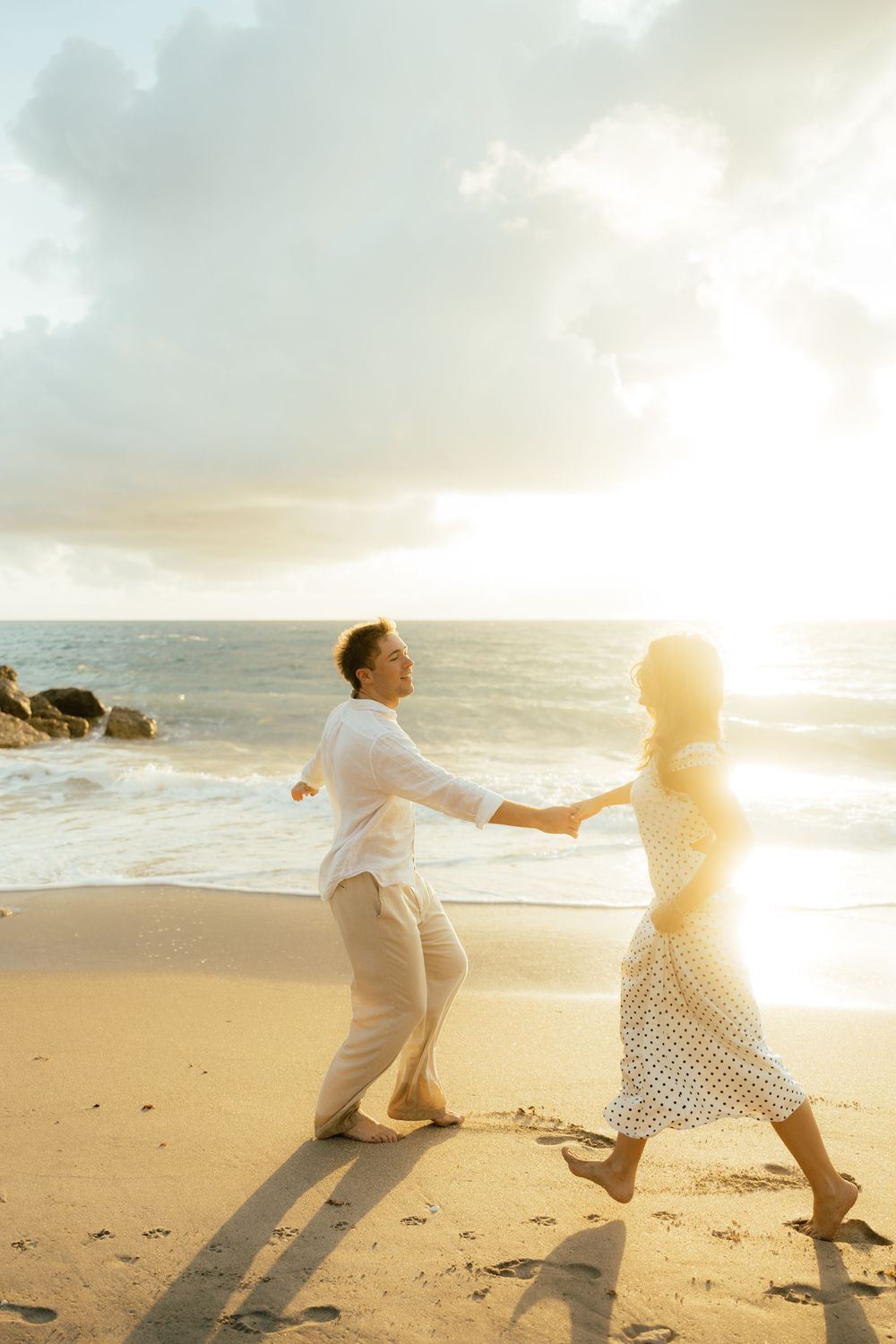 Playful sunrise beach engagement photos with golden light and bright blue waters. Jacksonville Engagement Photographer - Lindsay McDow Photo