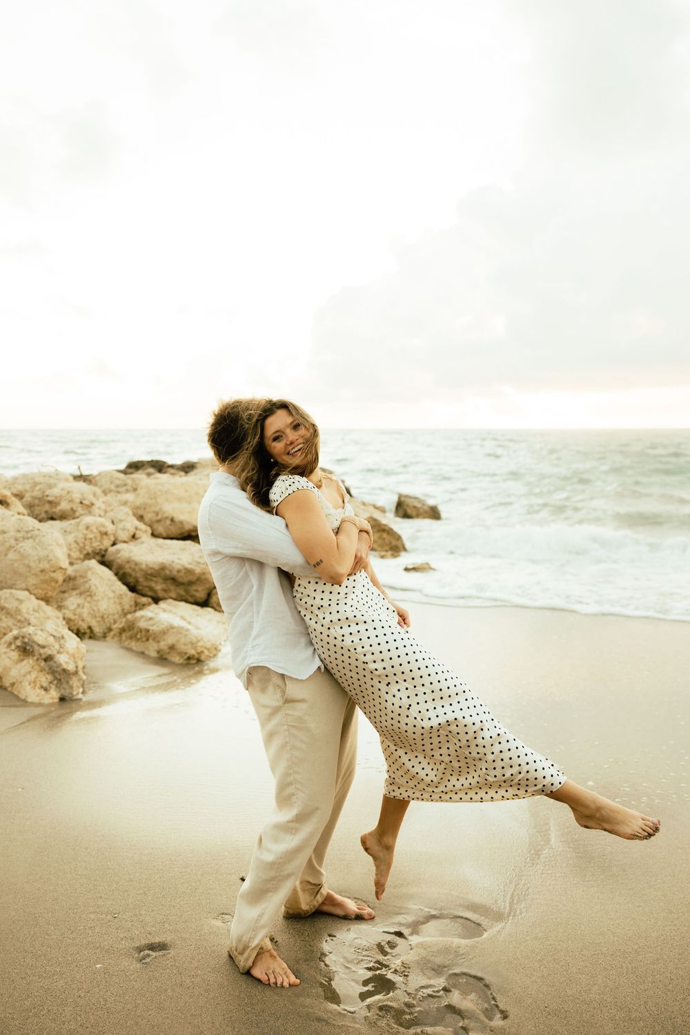 Playful sunrise beach engagement photos with golden light and bright blue waters. Jacksonville Engagement Photographer - Lindsay McDow Photo