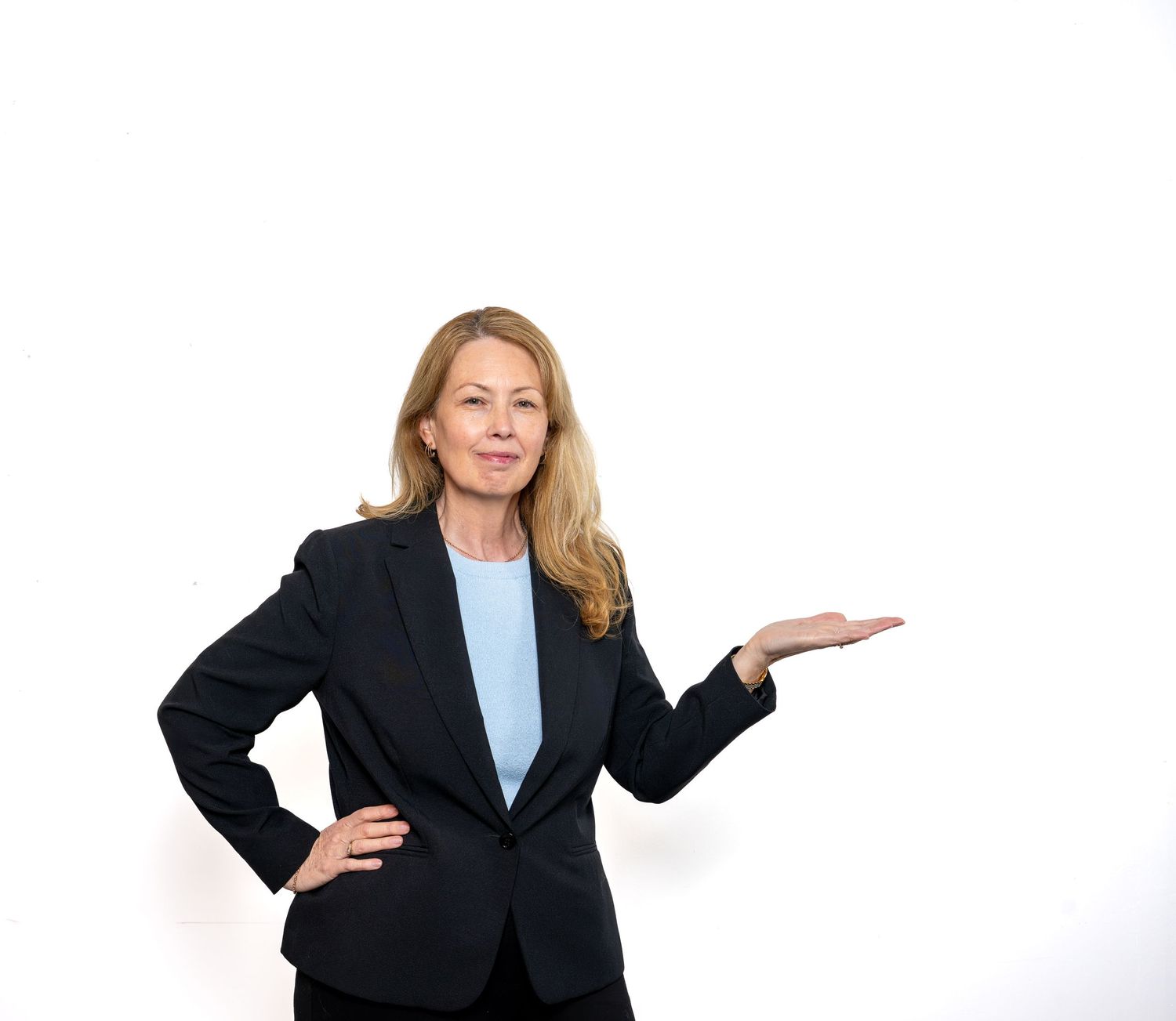 Professional businesswoman in dark blazer gesturing with open hand on white background.