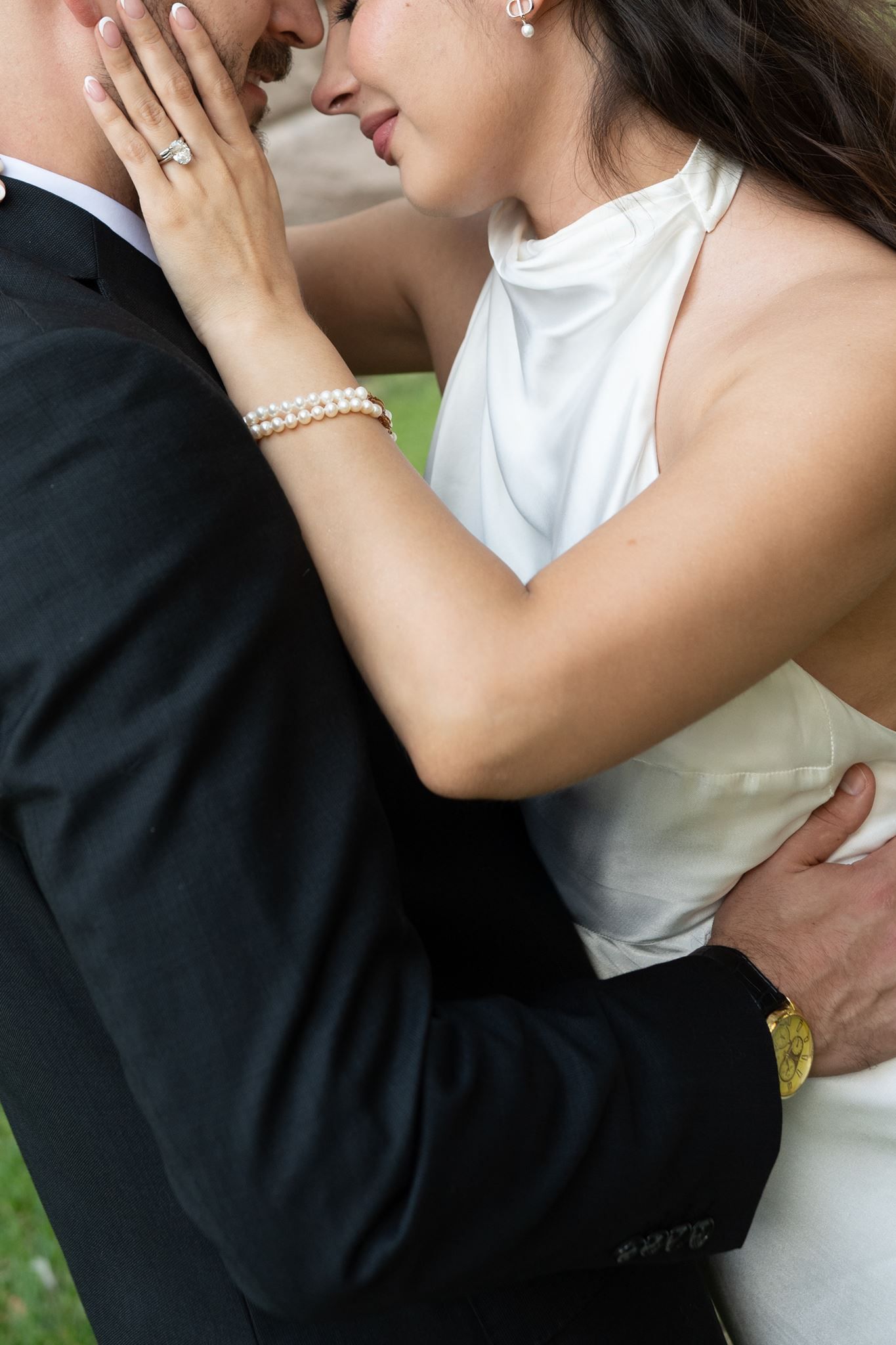 Close up image of a bride and groom snuggling close with their heads touching.