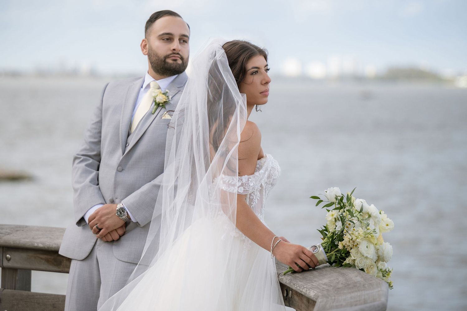 Bride and groom at the boardwalk railing overlooking the Indian River at the Mansion at Tuckahoe