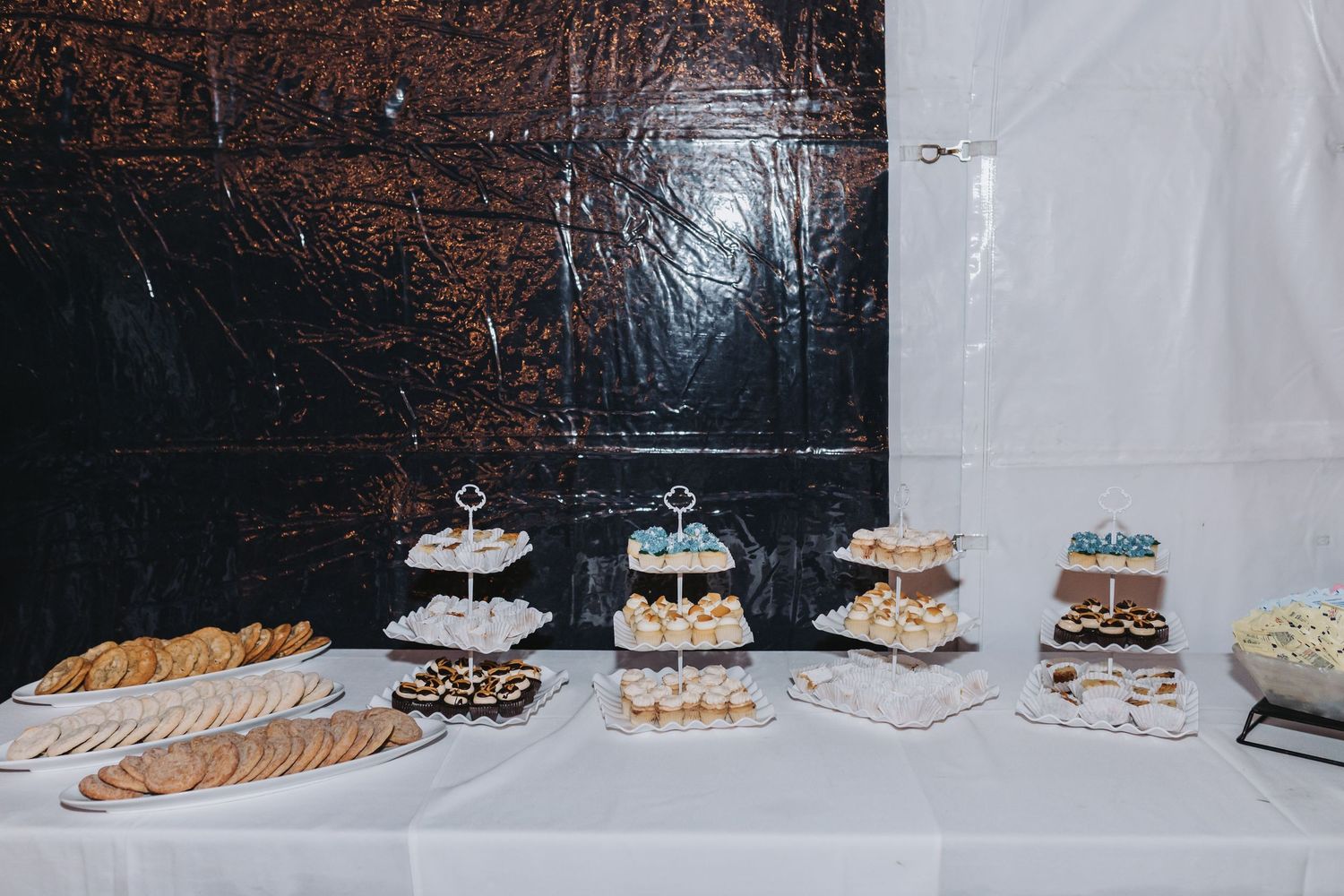 Elegant wedding dessert table featuring tiered cake stands with macarons, cookies, and assorted sweet treats.