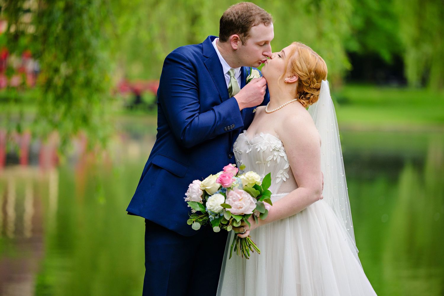 Bride and Groom wearing traditional wedding clothing standing in front of a pond before their May wedding at Gervasi Vineyard in Canton Ohio