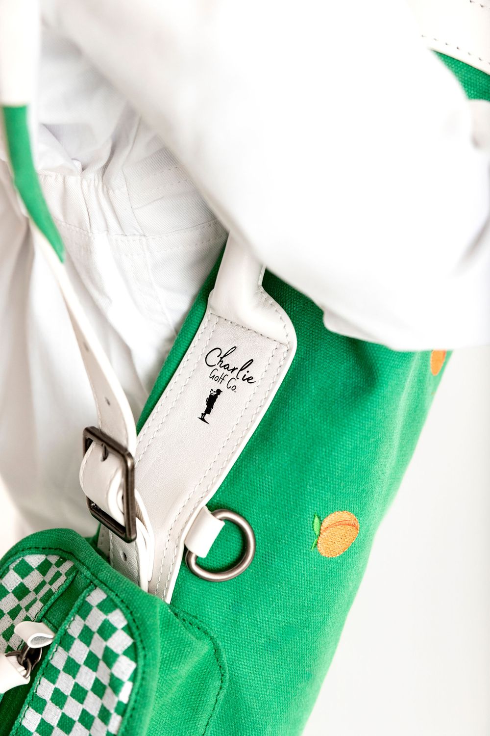 Green golf bag with white leather strap, checkered pocket, and Charlie built it brand label.