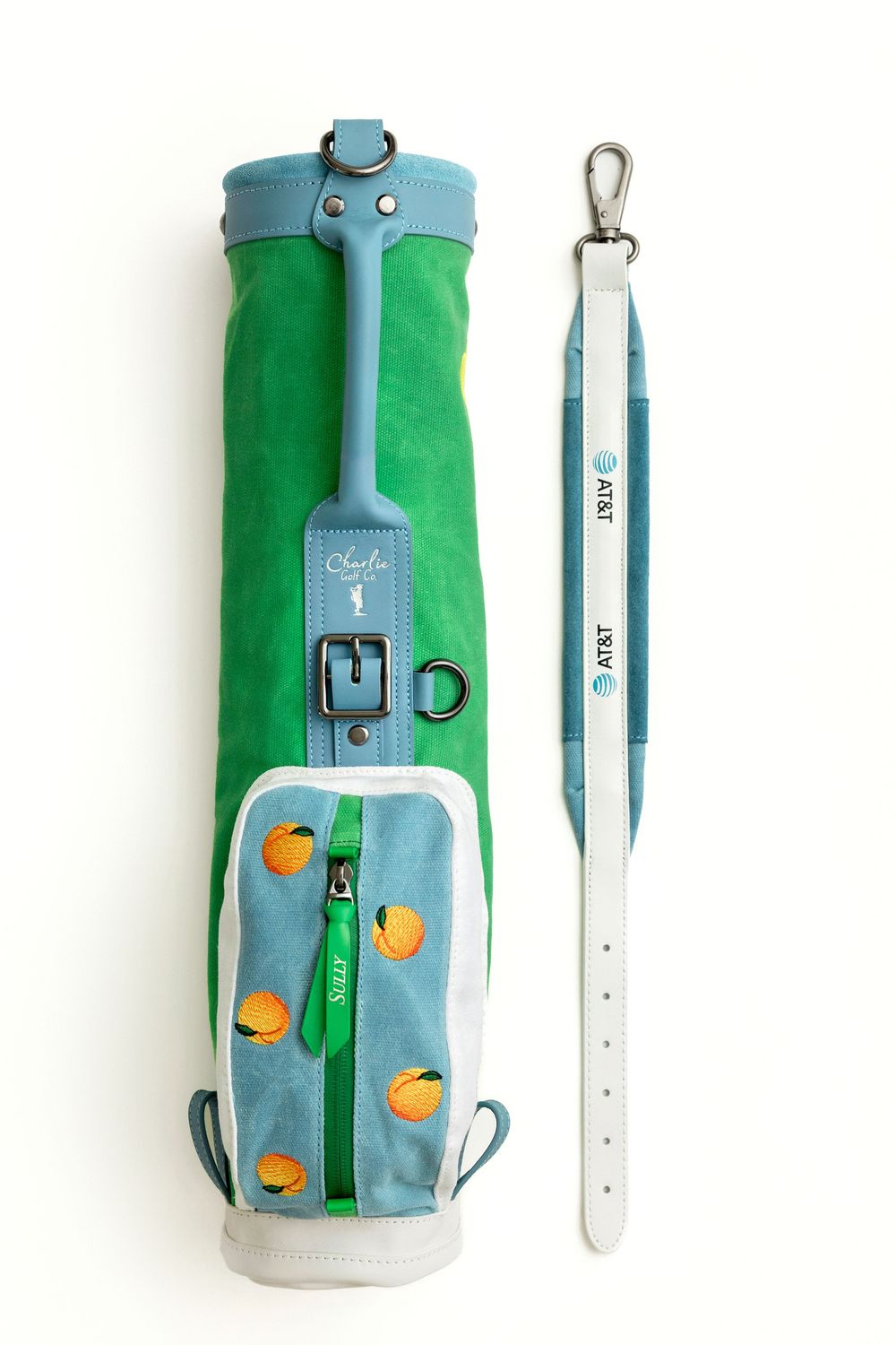 Green and blue AT&T branded golf bag with orange fruit embroidery and matching white shoulder strap.