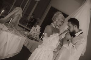 Black and white photo of a bride and groom sharing a tender moment during their elegant wedding reception.