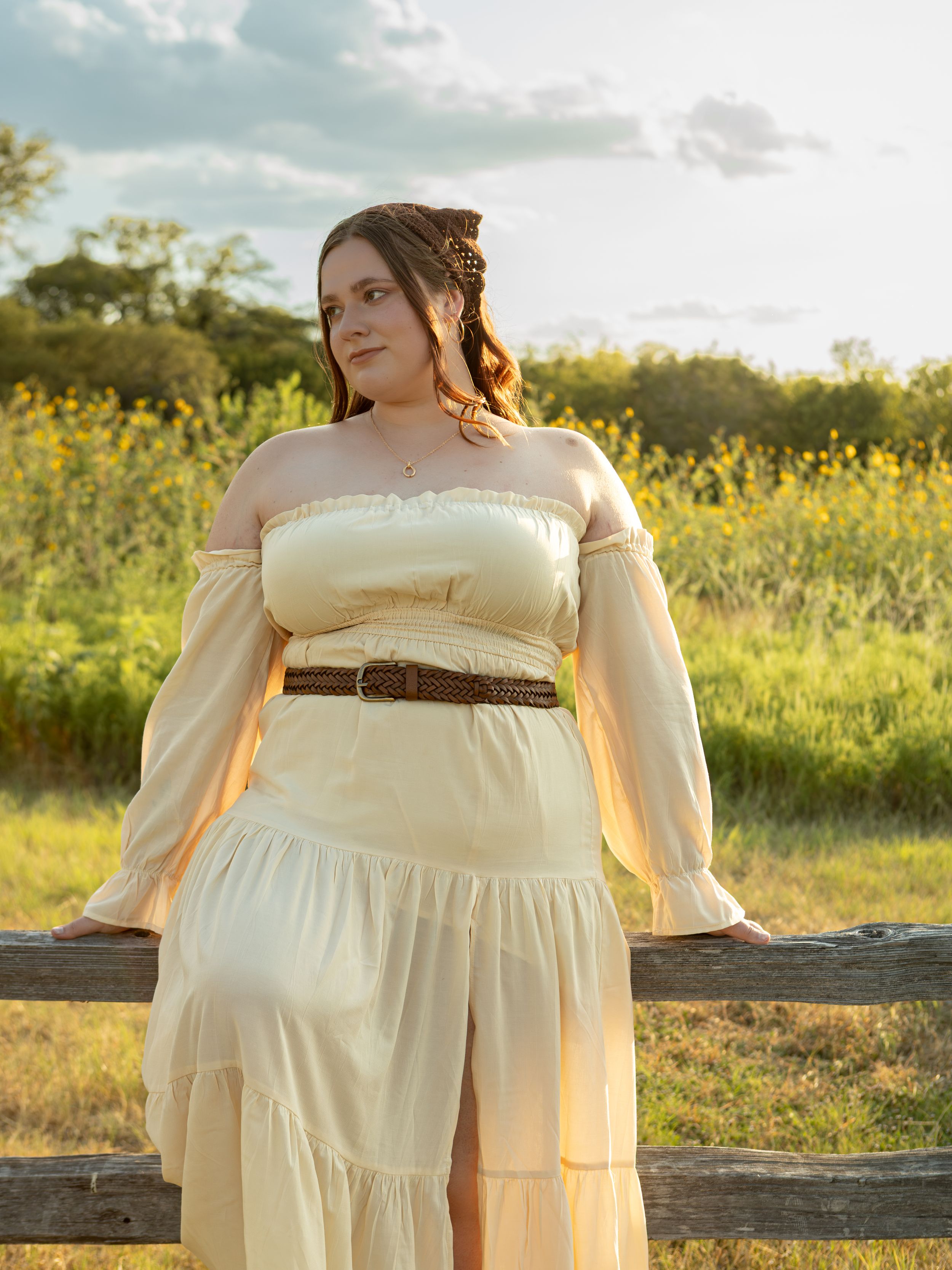 women sitting on fence in yellow dress at common ford ranch.