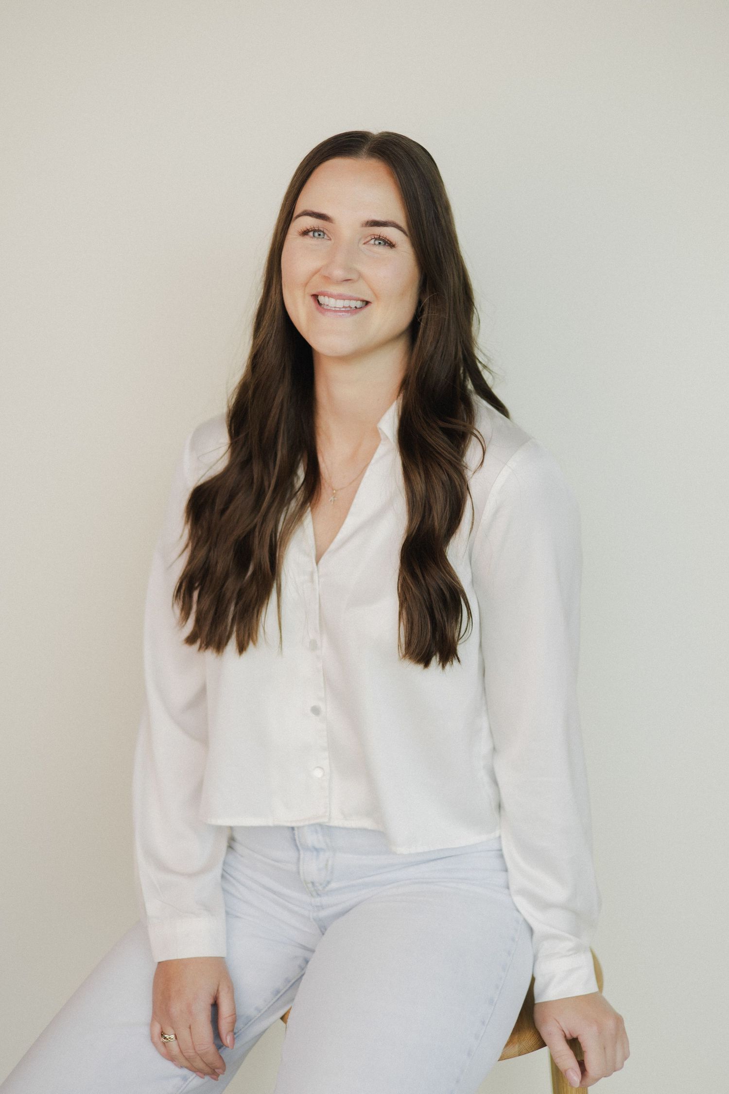 Woman seated on stool smiling at camera