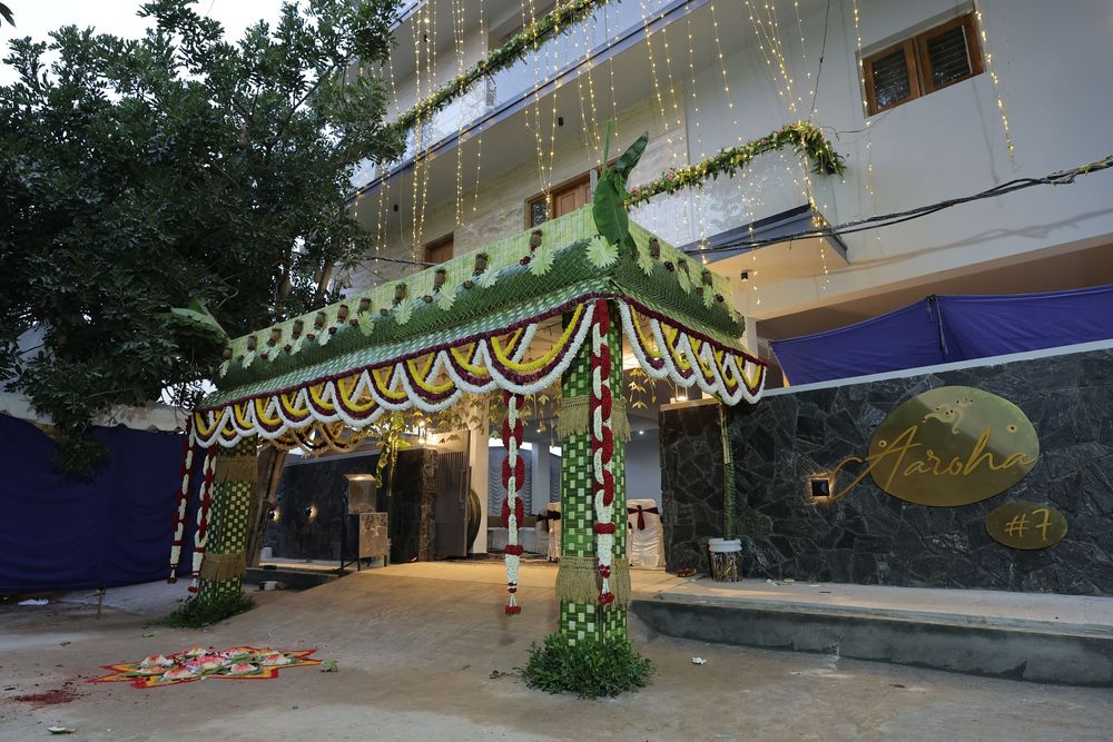 Decorated Indian building entrance with floral archway, marigold garlands, and colorful ornaments for a festive celebration.