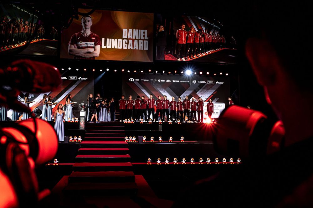 Daniel Lundgaard name display at a dramatic red-lit esports arena event with team on stage.