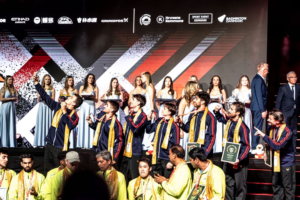 Award ceremony on stage with team in yellow jackets receiving trophies at an esports or gaming championship event.
