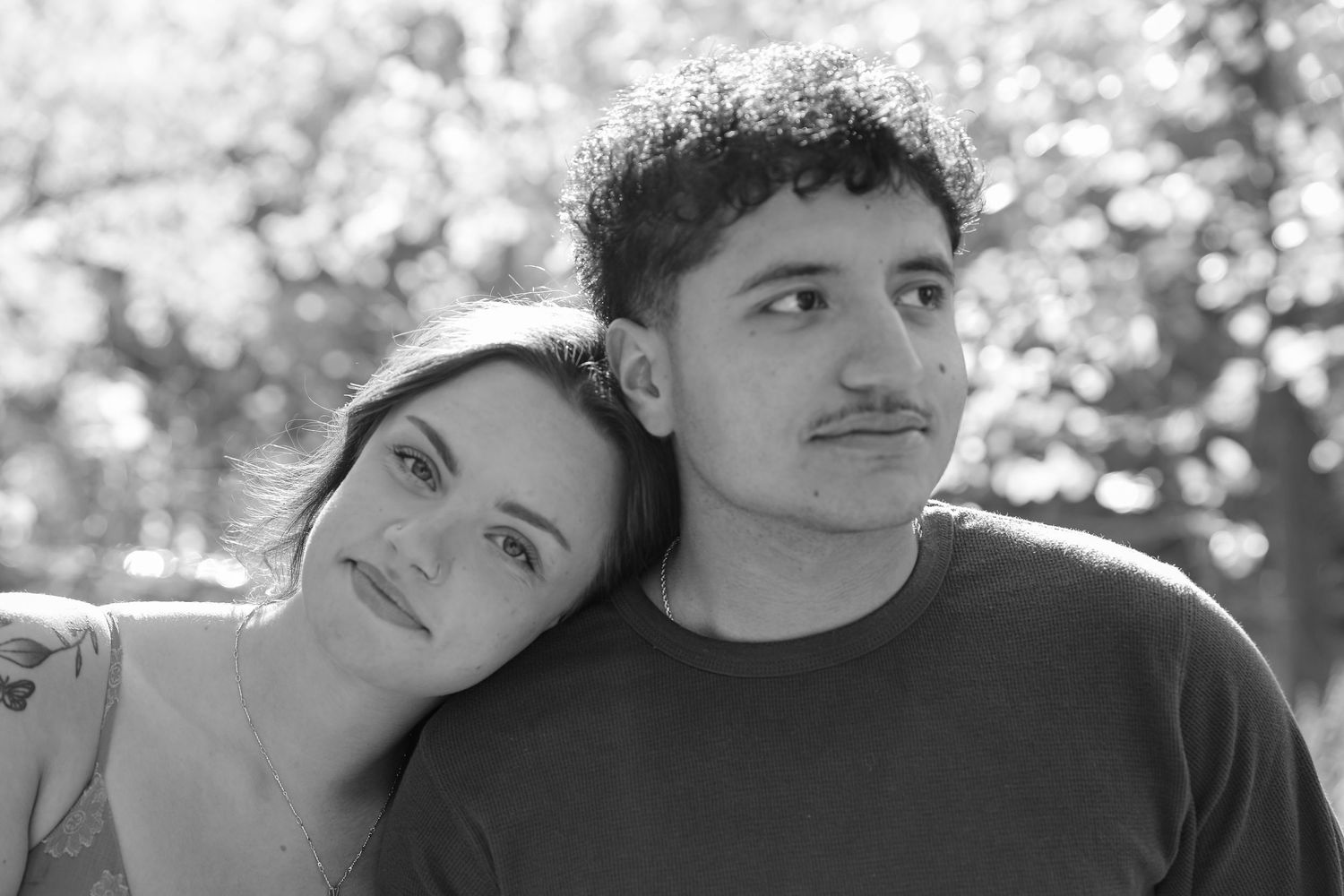 Black and white photo of a couple embracing, woman smiling as she holds man's head tenderly.