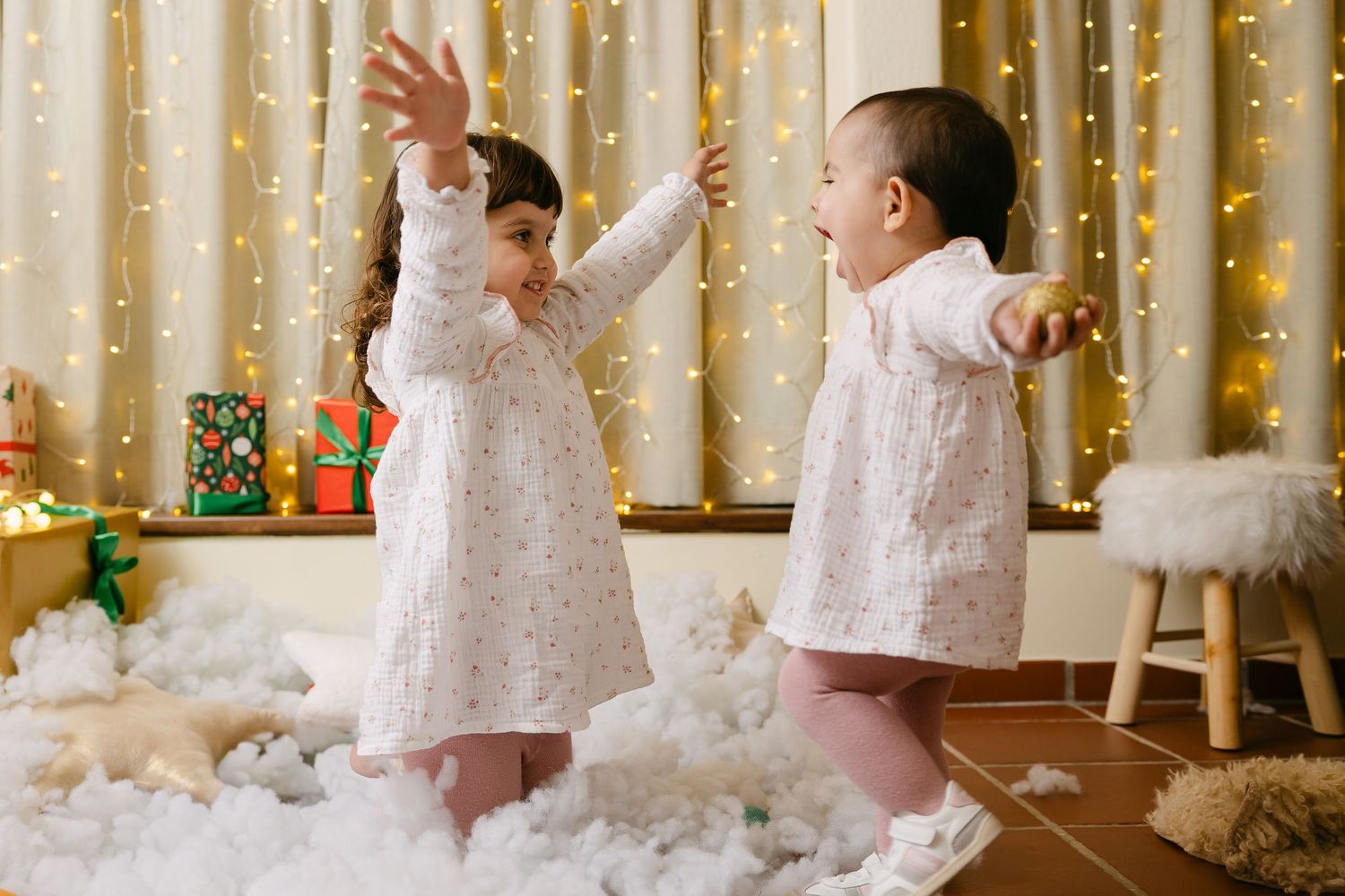 Holiday portrait setup with greenery garland and warm lighting against neutral background.