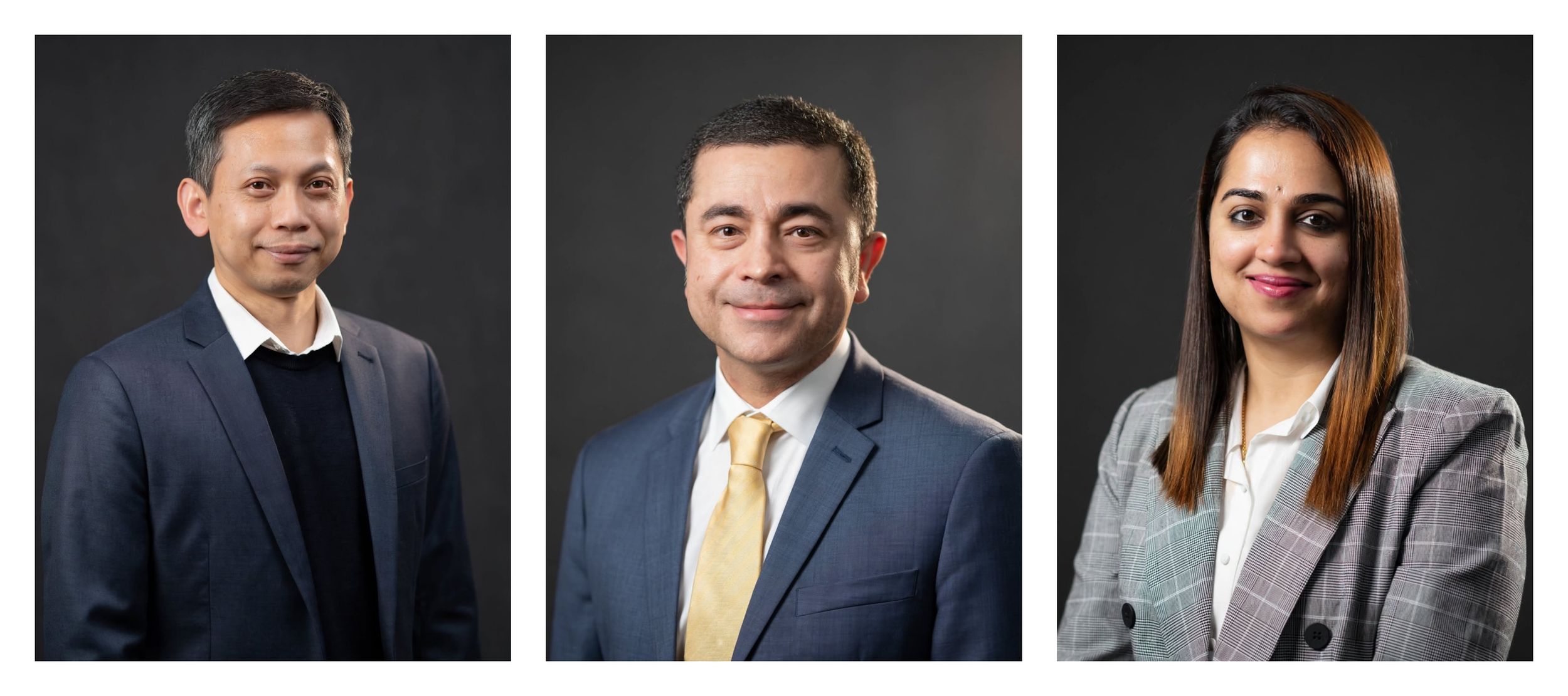 Three professional business people posing for formal corporate headshots against a dark gray background.