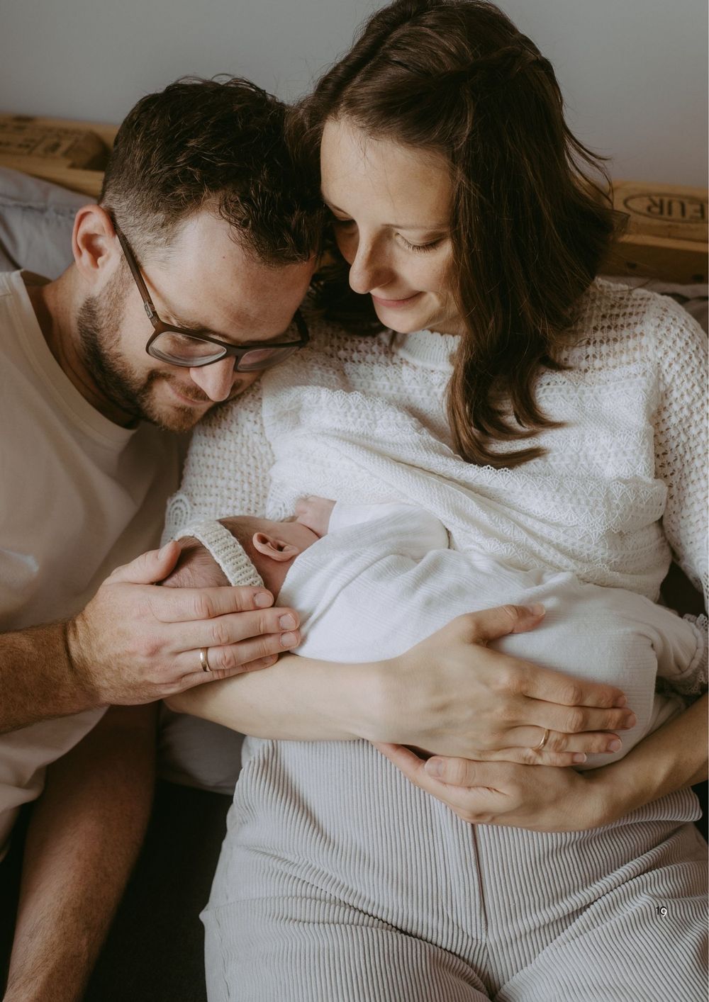 New parents tenderly hold their newborn baby, with text reading Bereit fur eure Geschichte in white serif font.