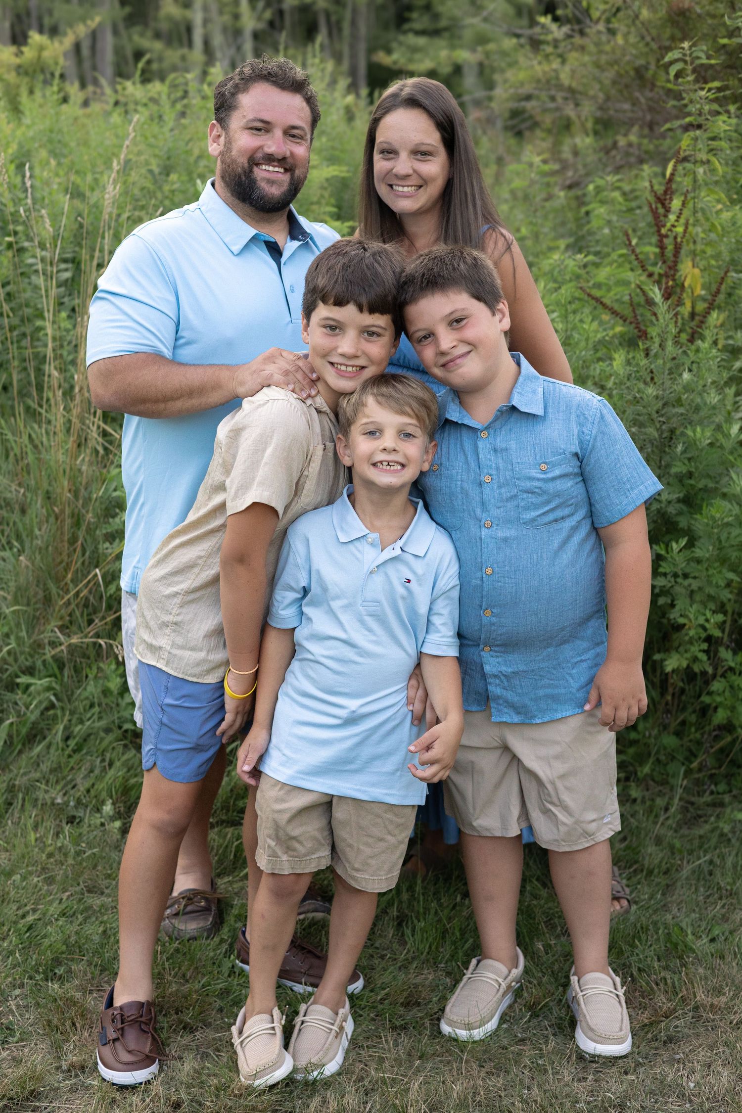 Family smiling for a portrait during an outdoor photo session