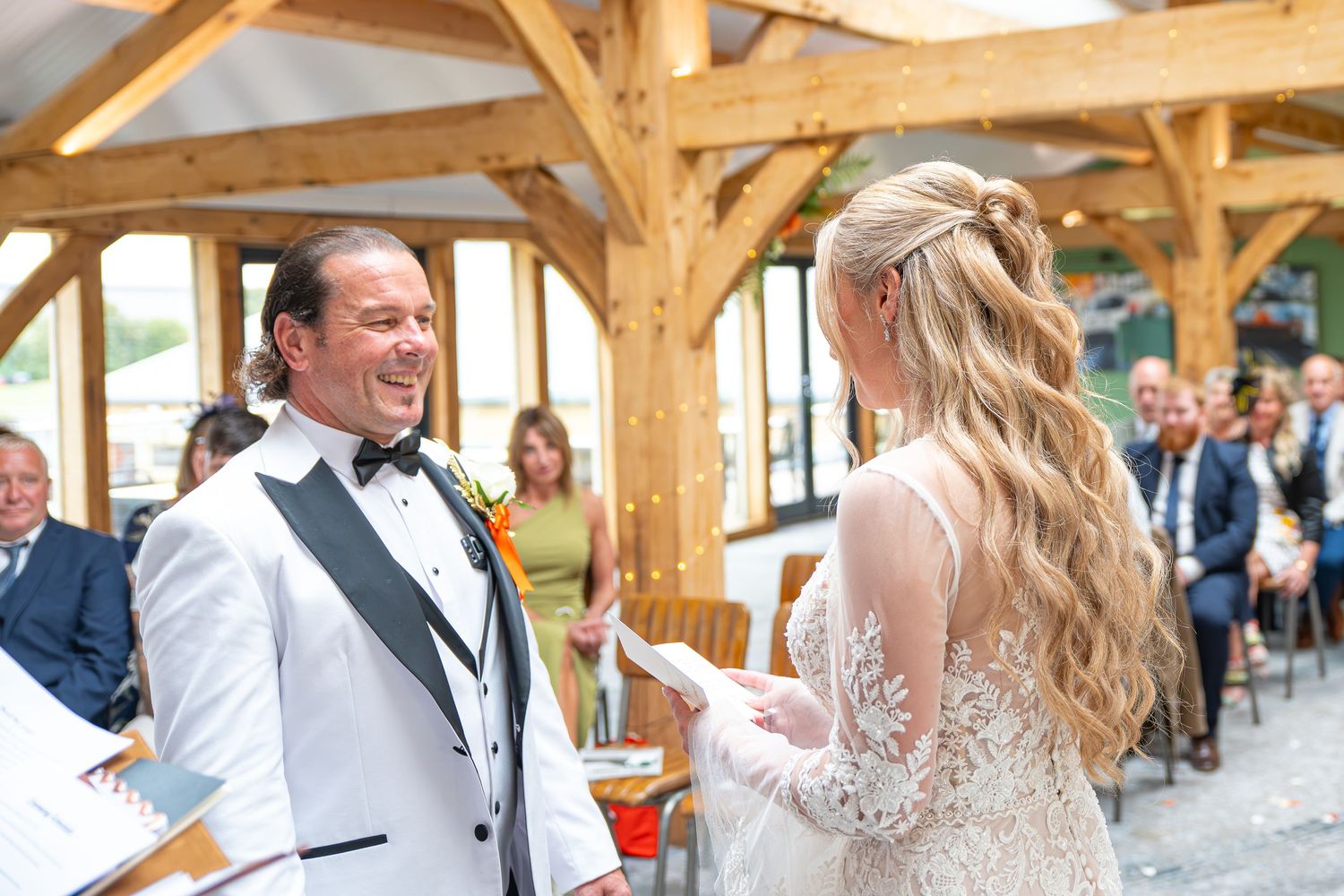 Bride and groom exchanging vows at wedding ceremony with guests seated behind.Yorkshire, Sheffield, Lincolnshire, UK, Leeds, Rotherham