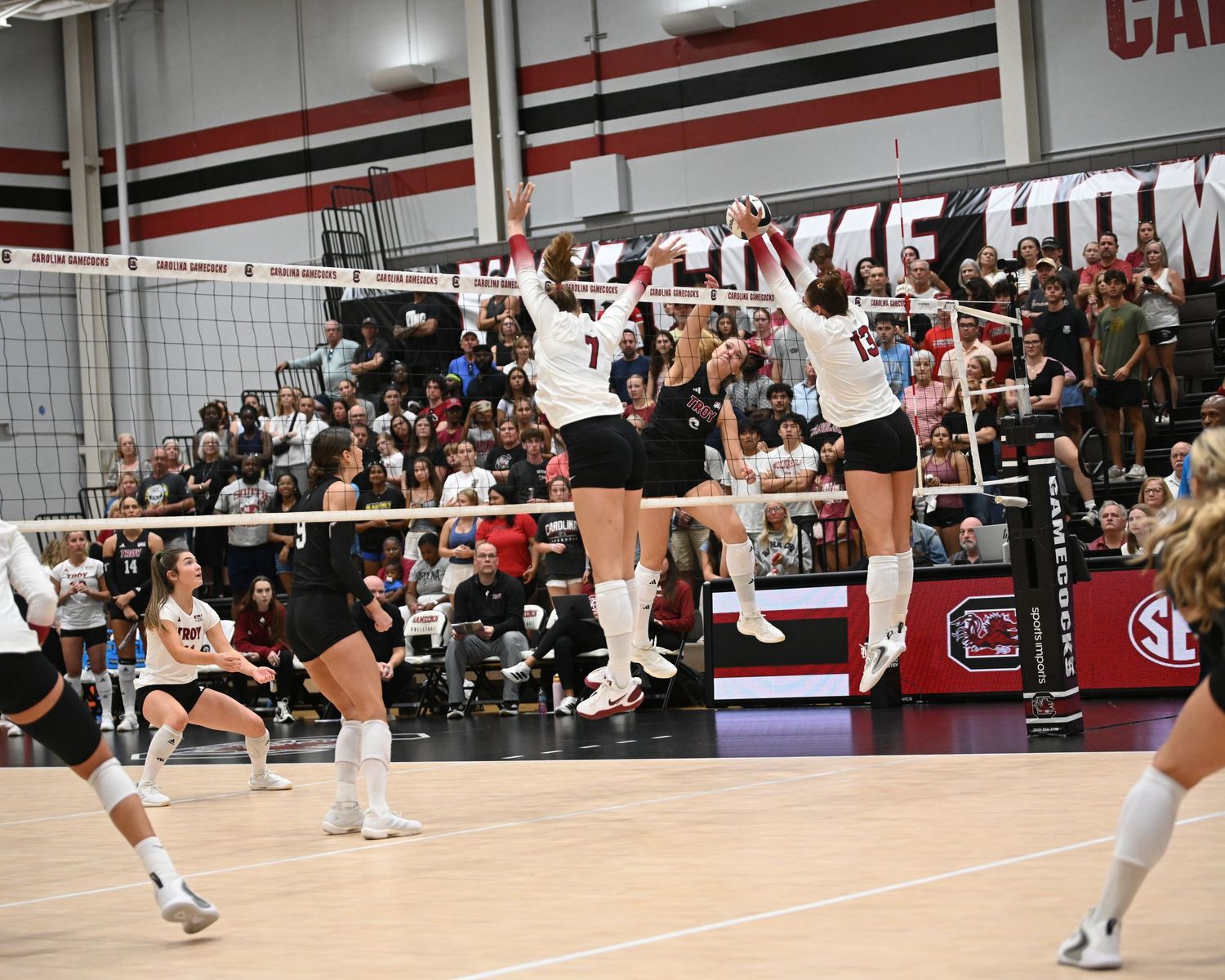 Two South Carolina volleyball players jump together to block an attack at the net.
