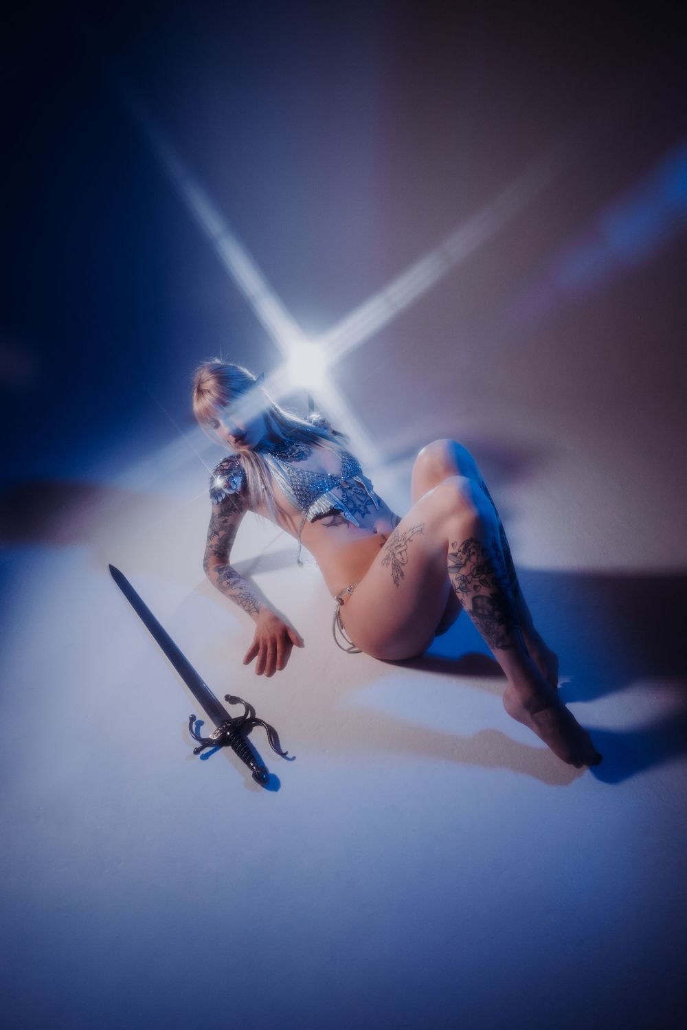 A dynamic sequence of a dancer performing aerial movements in a blue-lit studio against a dark background.