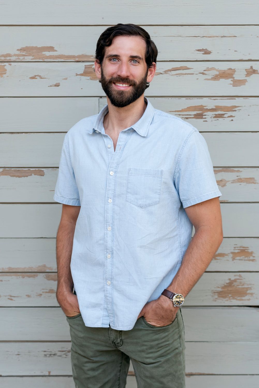 Portrait of a man standing by a wall in Houston, TX, relaxed expression.