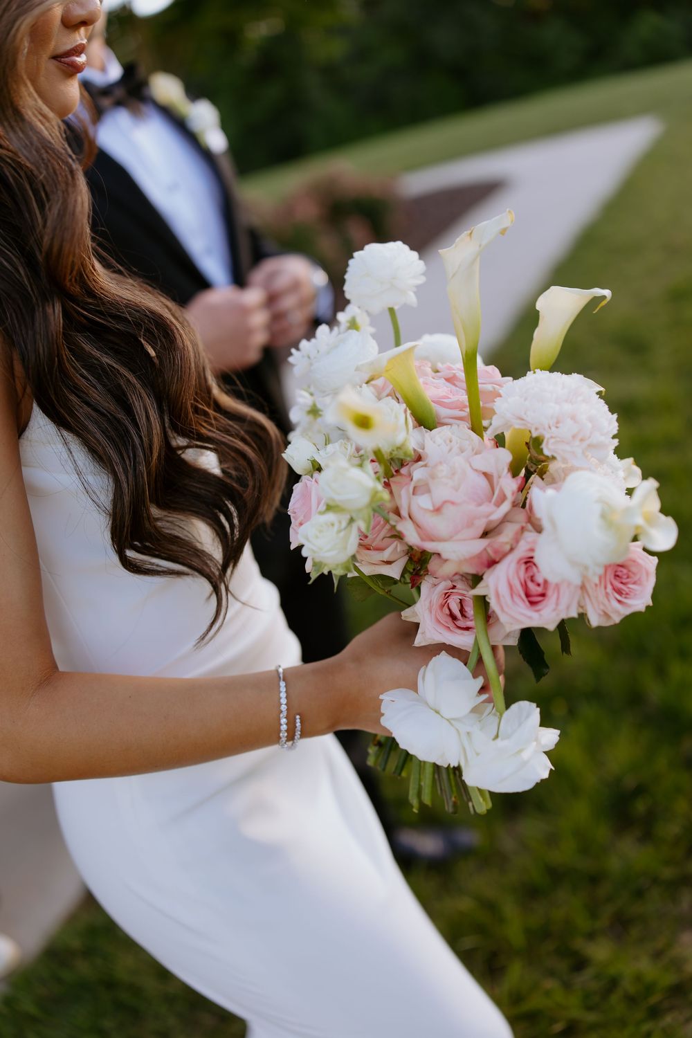 Elegant bridal bouquet featuring pink roses, white calla lilies and delicate florals.