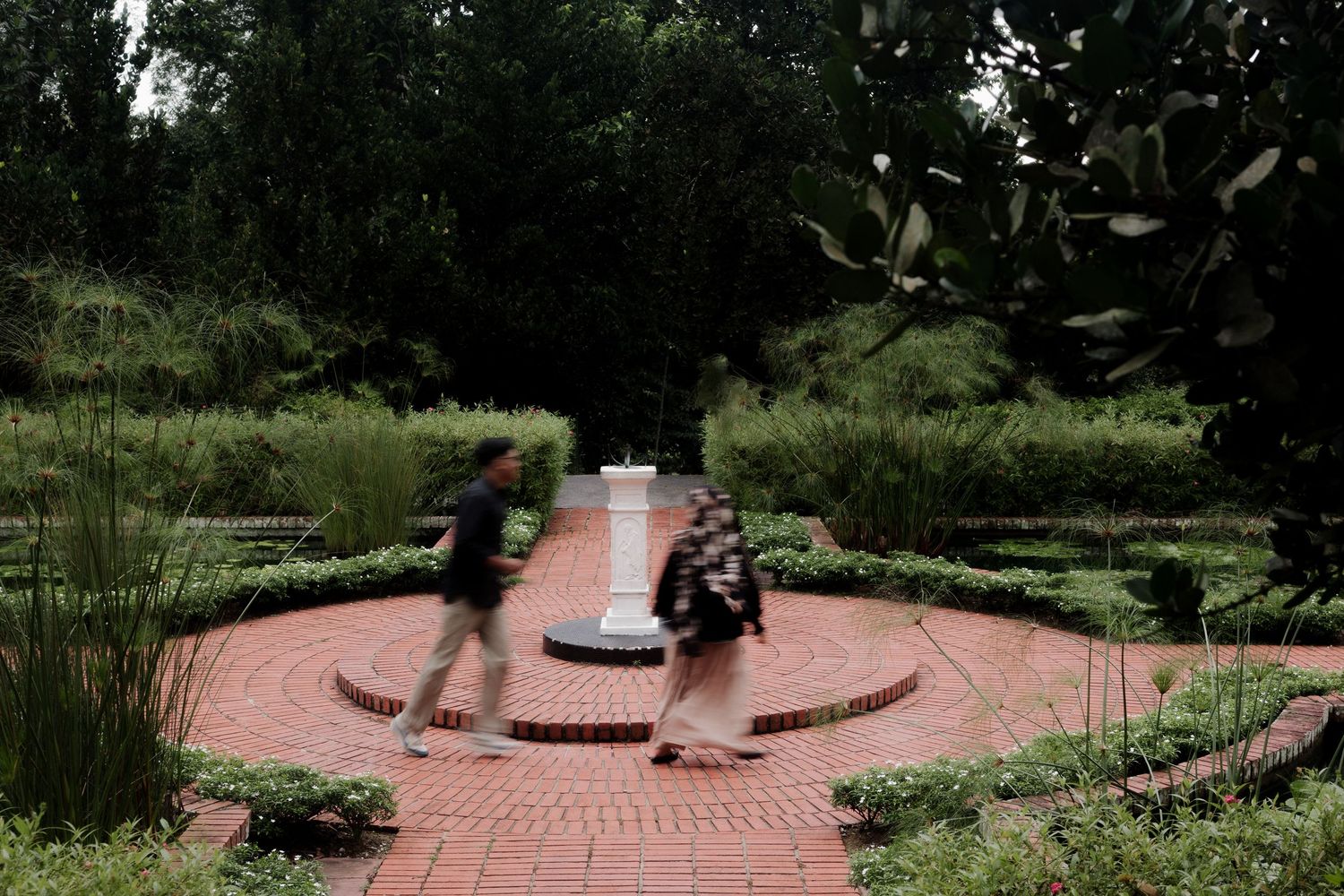 White gazebo wedding venue surrounded by lush greenery and landscaping.