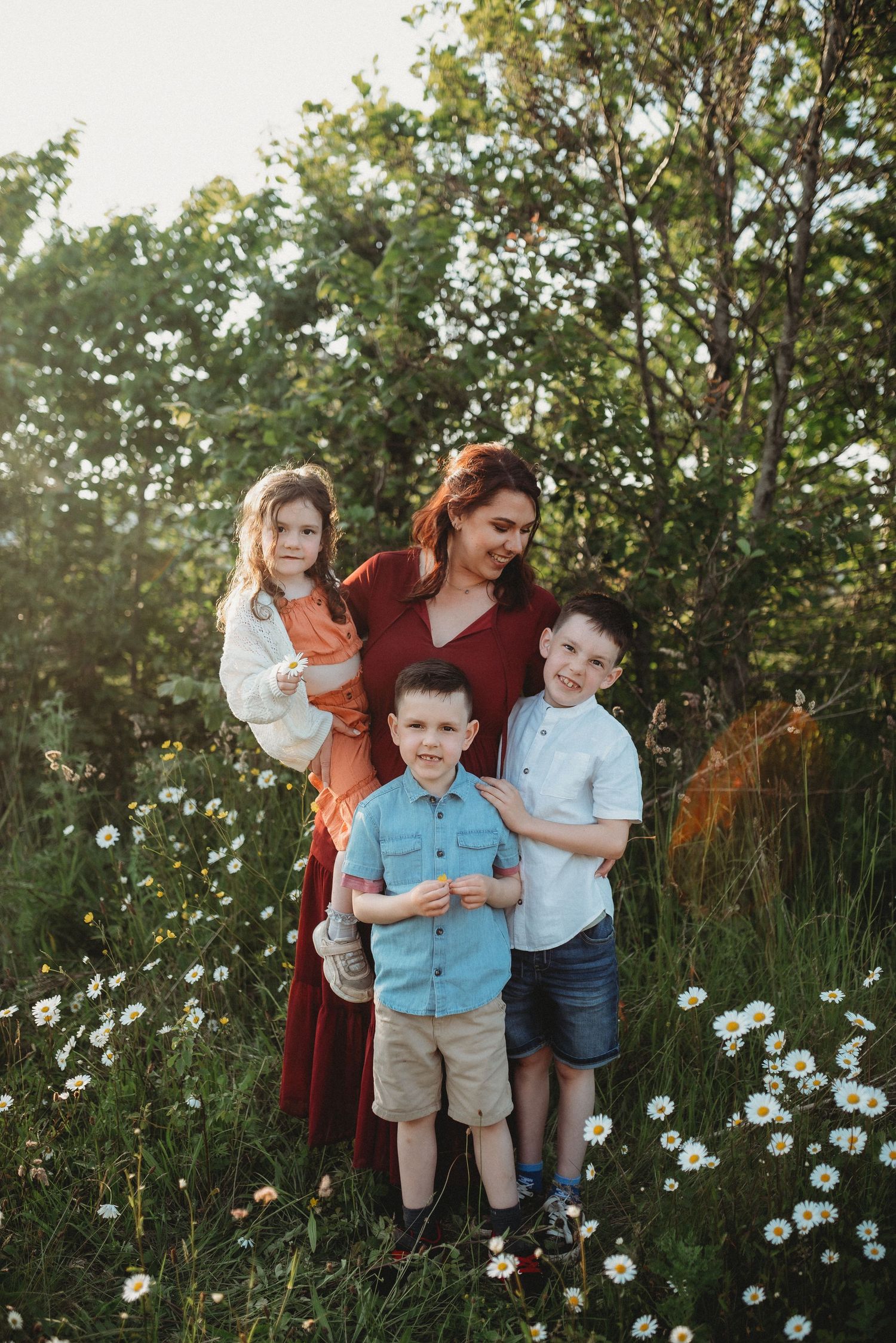 Family portrait session in a wildflower meadow during golden hour.