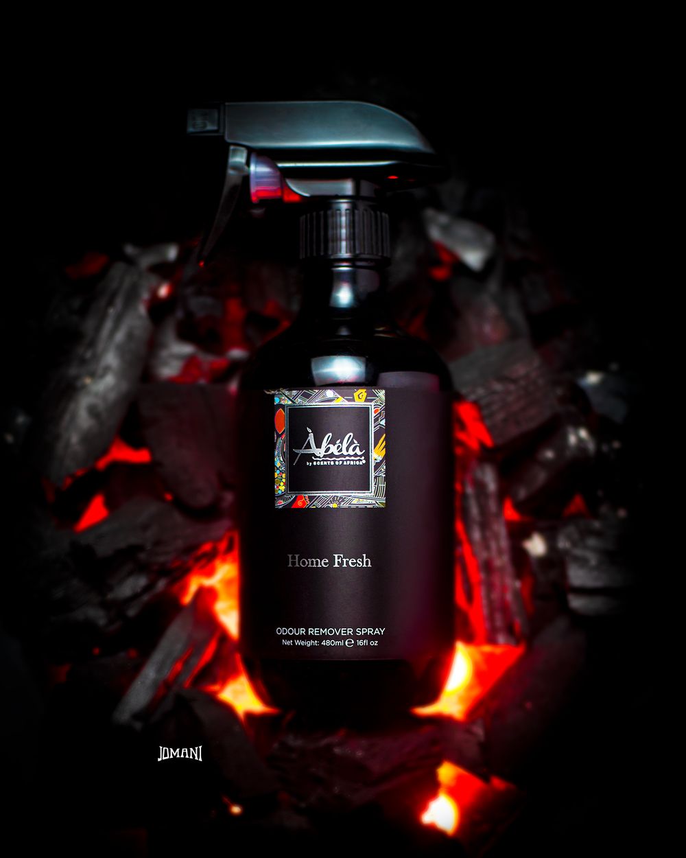 Abela Home Fresh odour remover spray bottle against glowing red hot charcoal background.