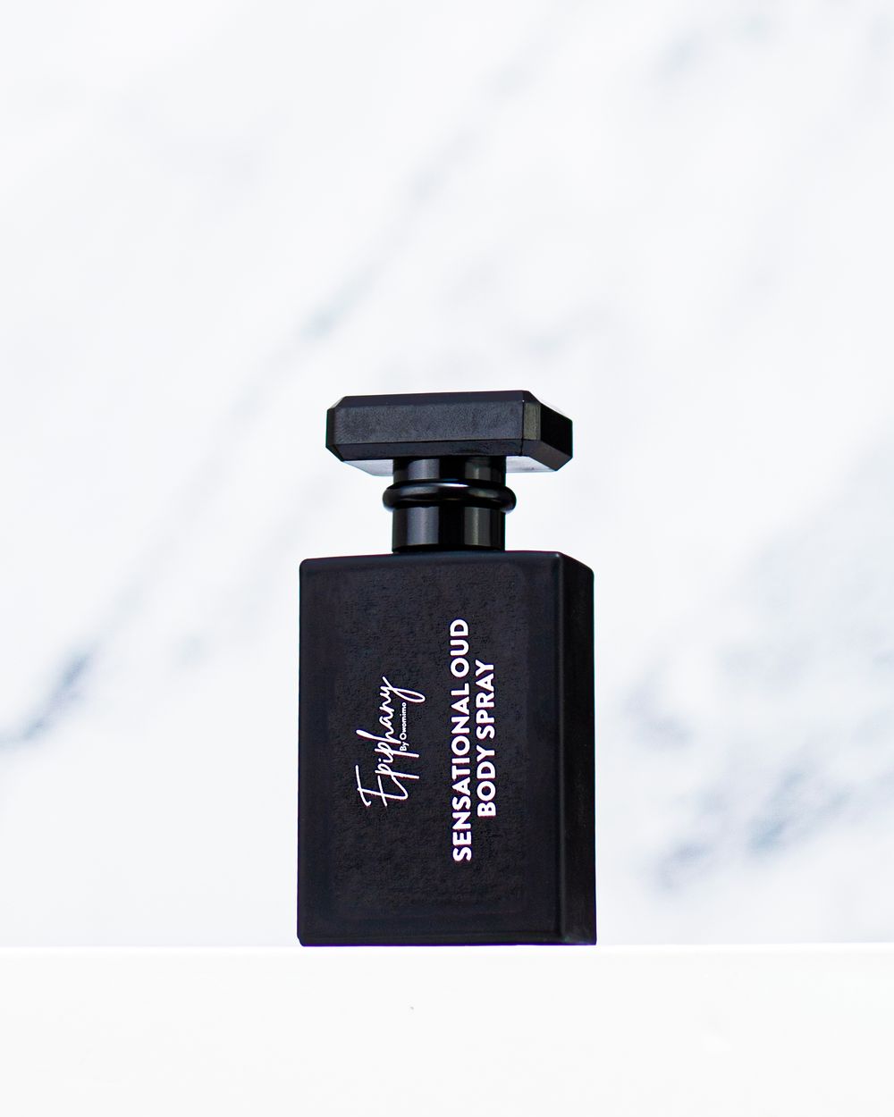Ephemery Sensational Oud black body spray bottle on white marble background.