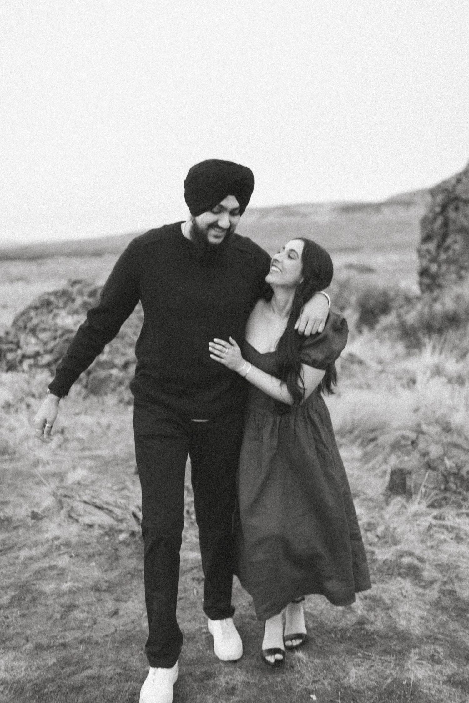 A tender embrace on a clifftop overlooking the misty ocean.