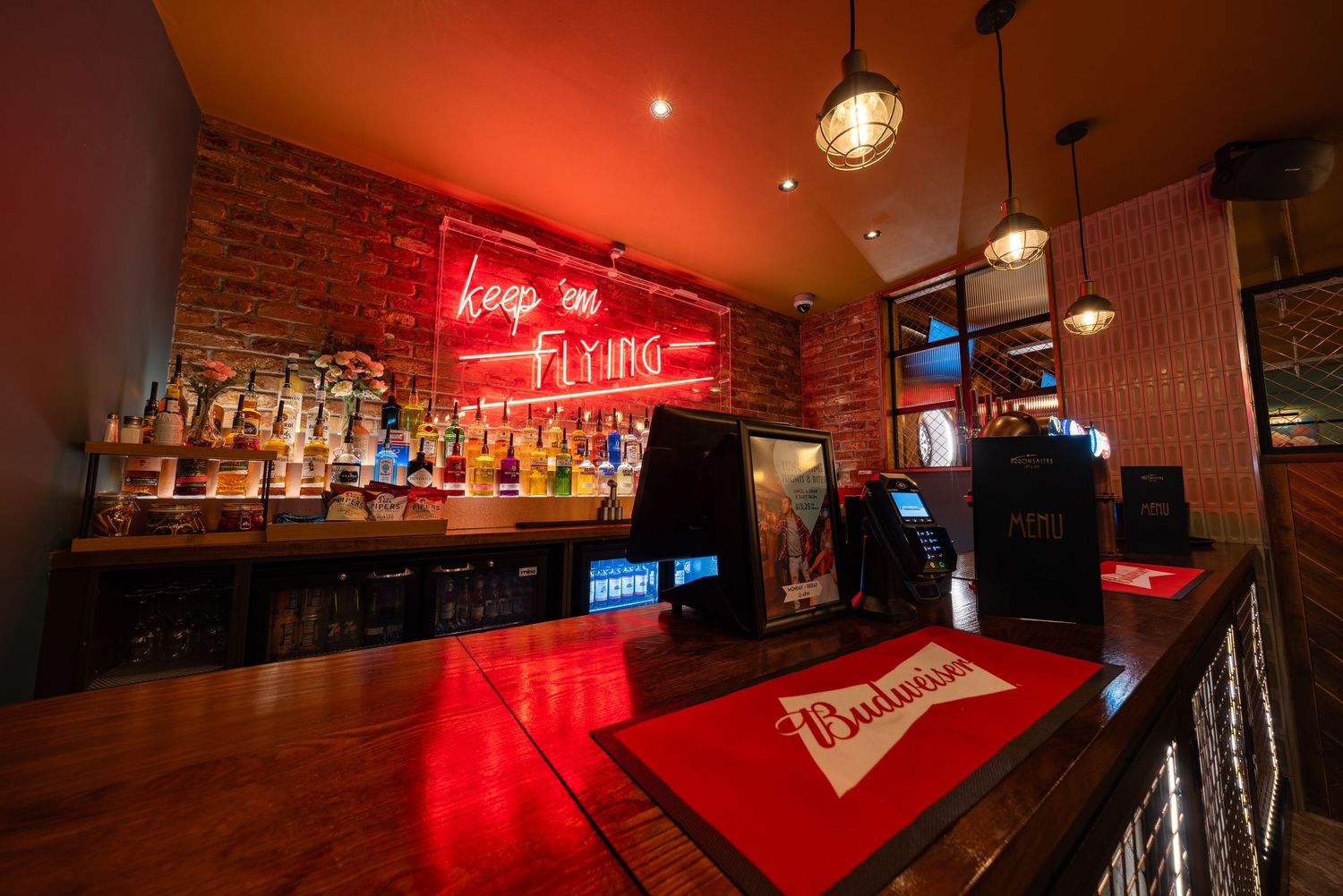 Retro home bar with red neon signage, dark wood counter and vintage lighting, games room interior photography