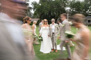 Motion-blurred wedding party dancing and celebrating outdoors.