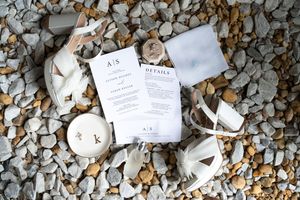 Wedding invitations and details arranged artistically on stone background.