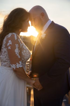Intimate sunset wedding portraits with lace dress details and golden backlighting.