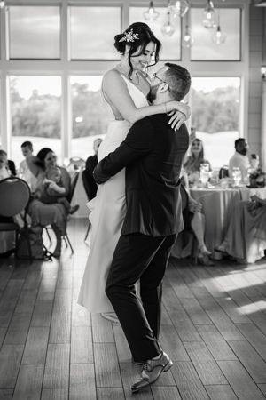 First dance in bright reception hall with large windows.
