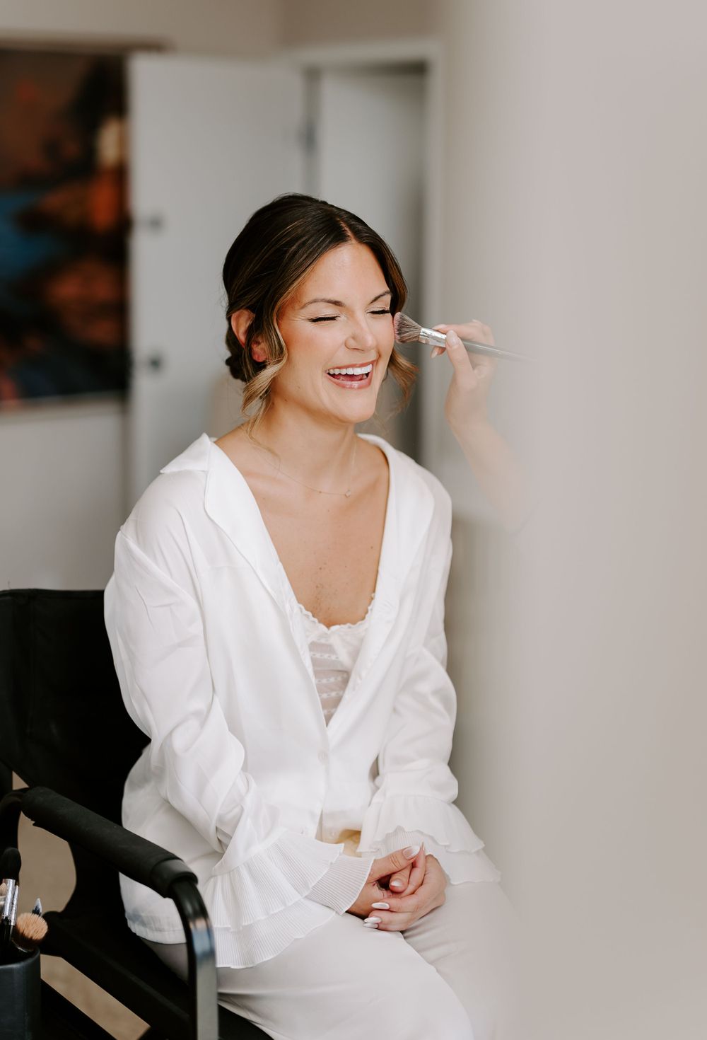 A candid moment during wedding day preparations in a bright room.