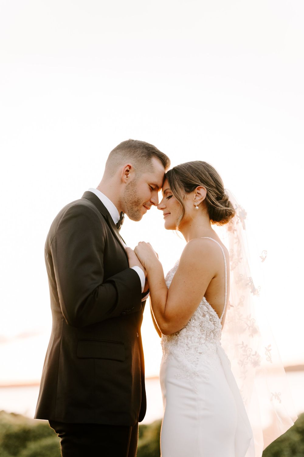 Intimate wedding portraits showing tender moments between newlyweds during sunset.