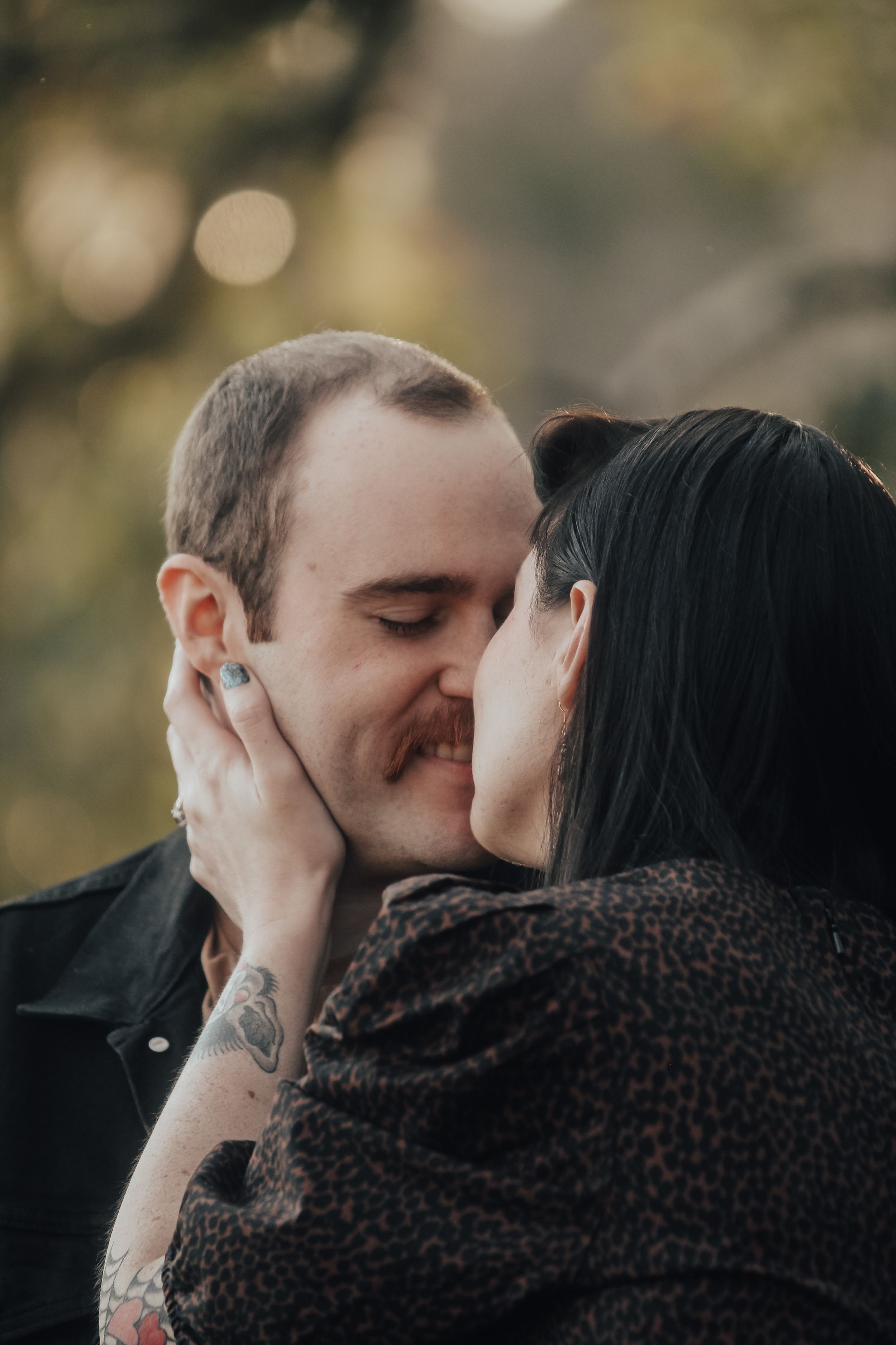 Romantic close-up of couple sharing intimate moment outdoors.
