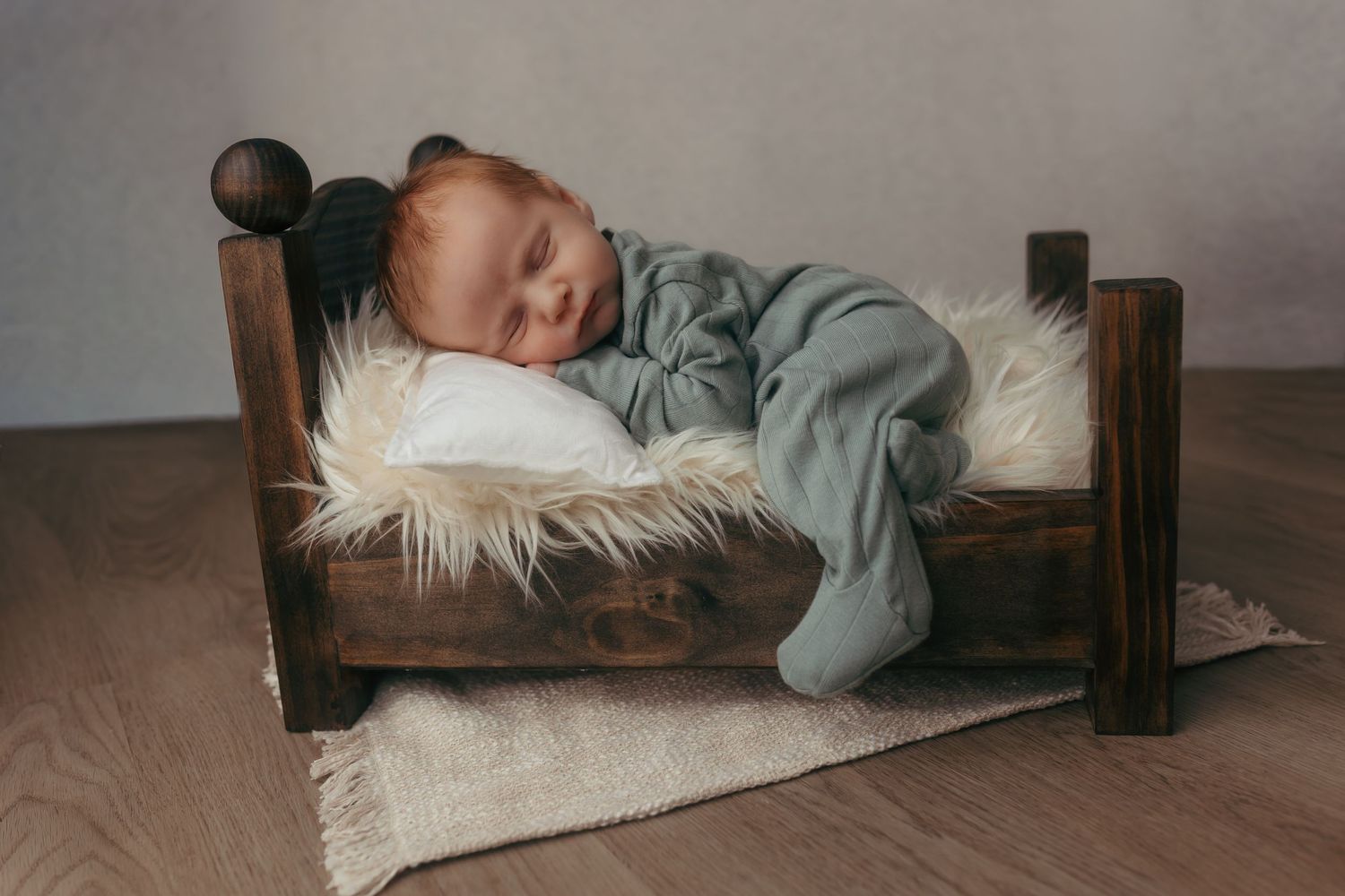 Newborn sleeping peacefully on bed during his relaxed newborn session in Schofield, wi.
